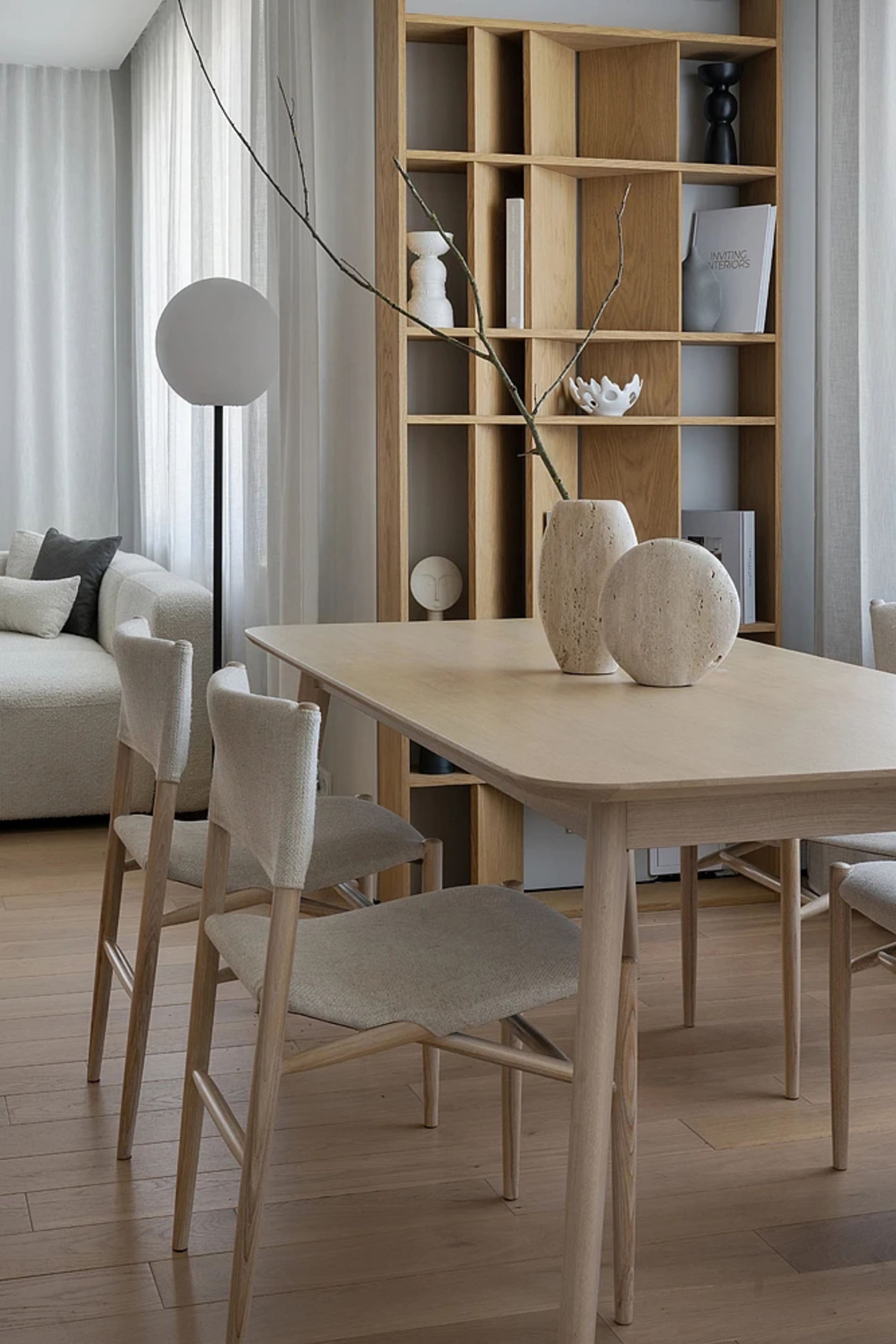 A modern living room with wooden furniture, a sofa, and a bookshelf.
