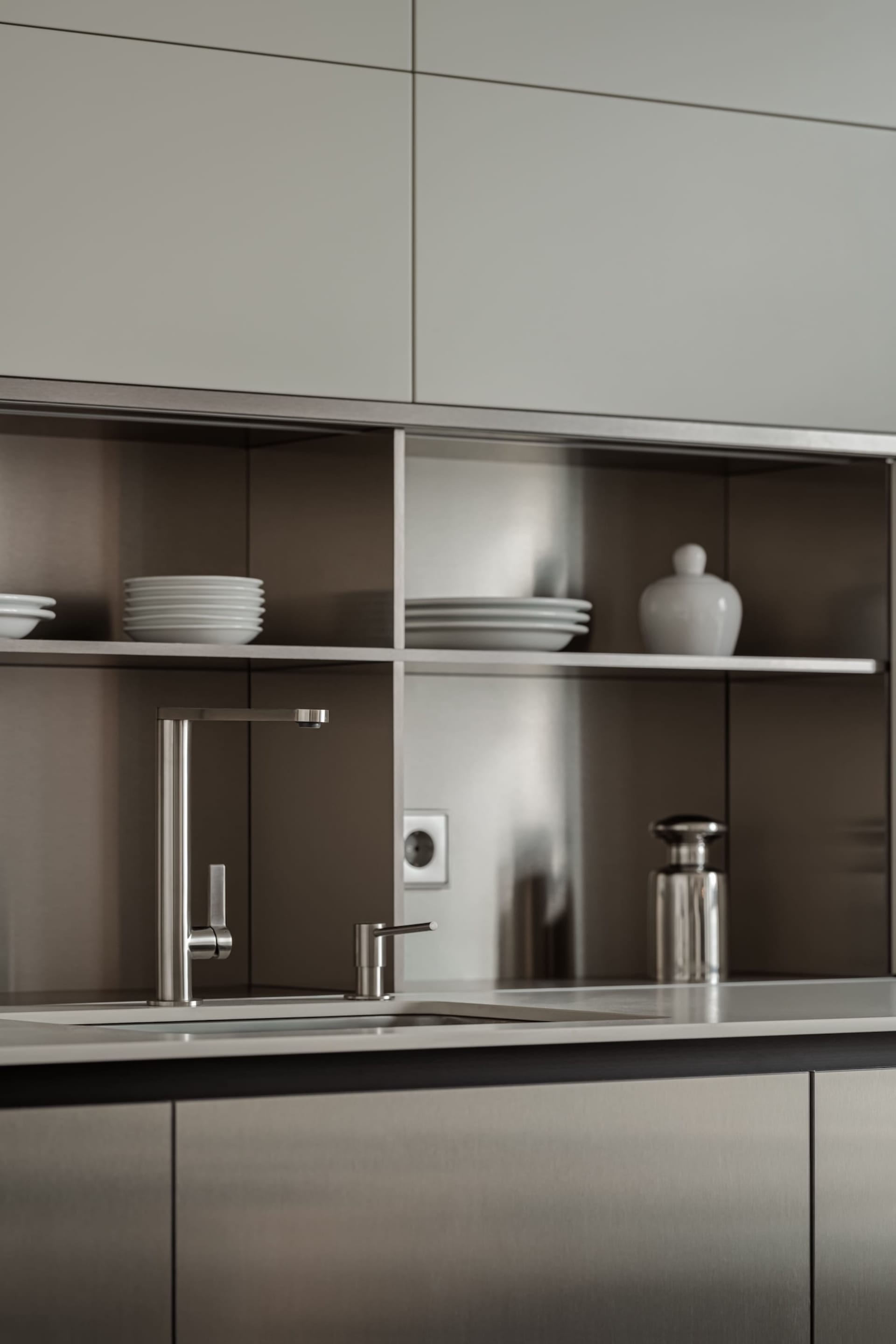 A modern residential kitchen featuring metallic surfaces and sleek design elements.
