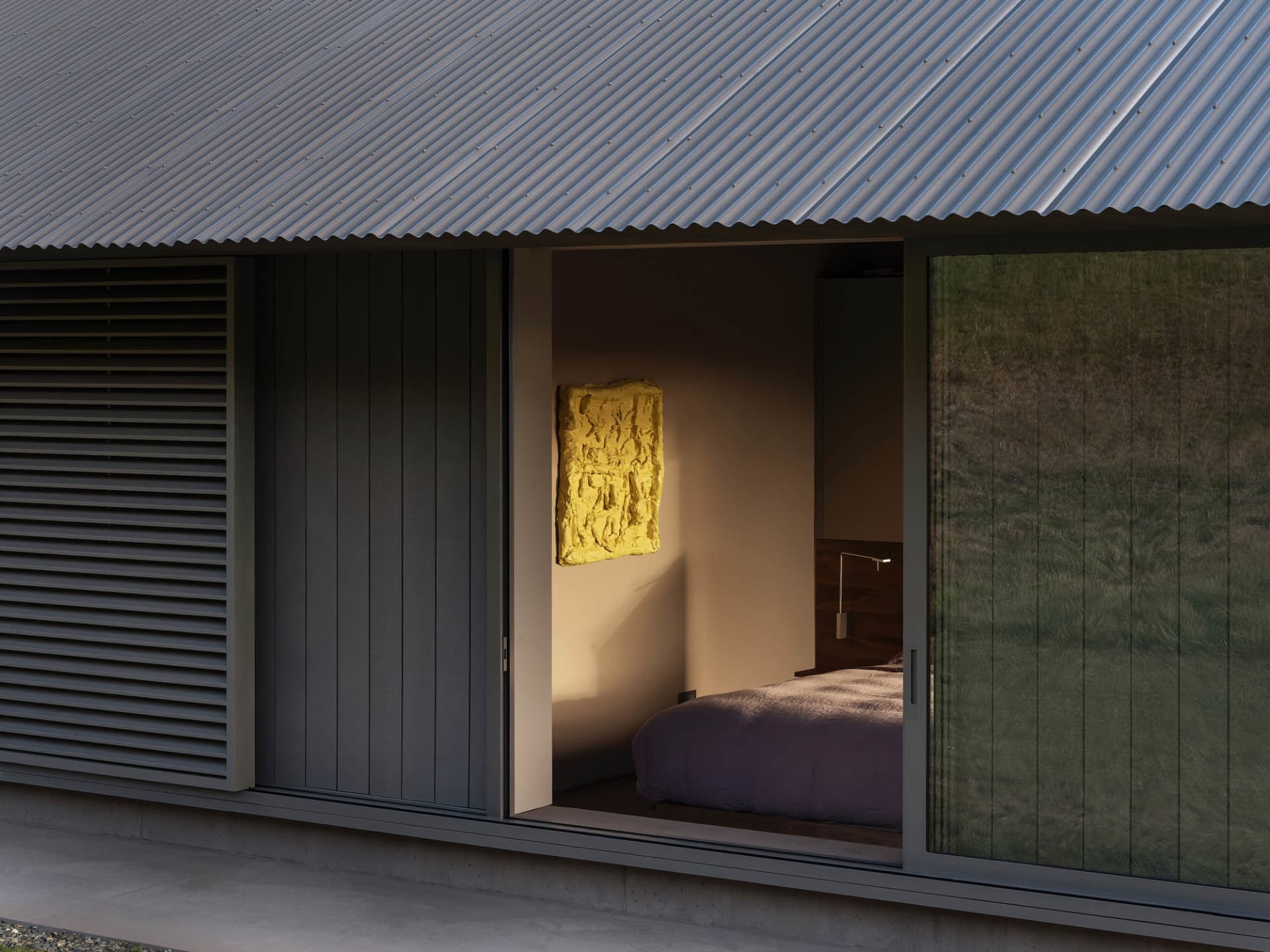 Modern bedroom featuring a metal-clad wall and large windows.
