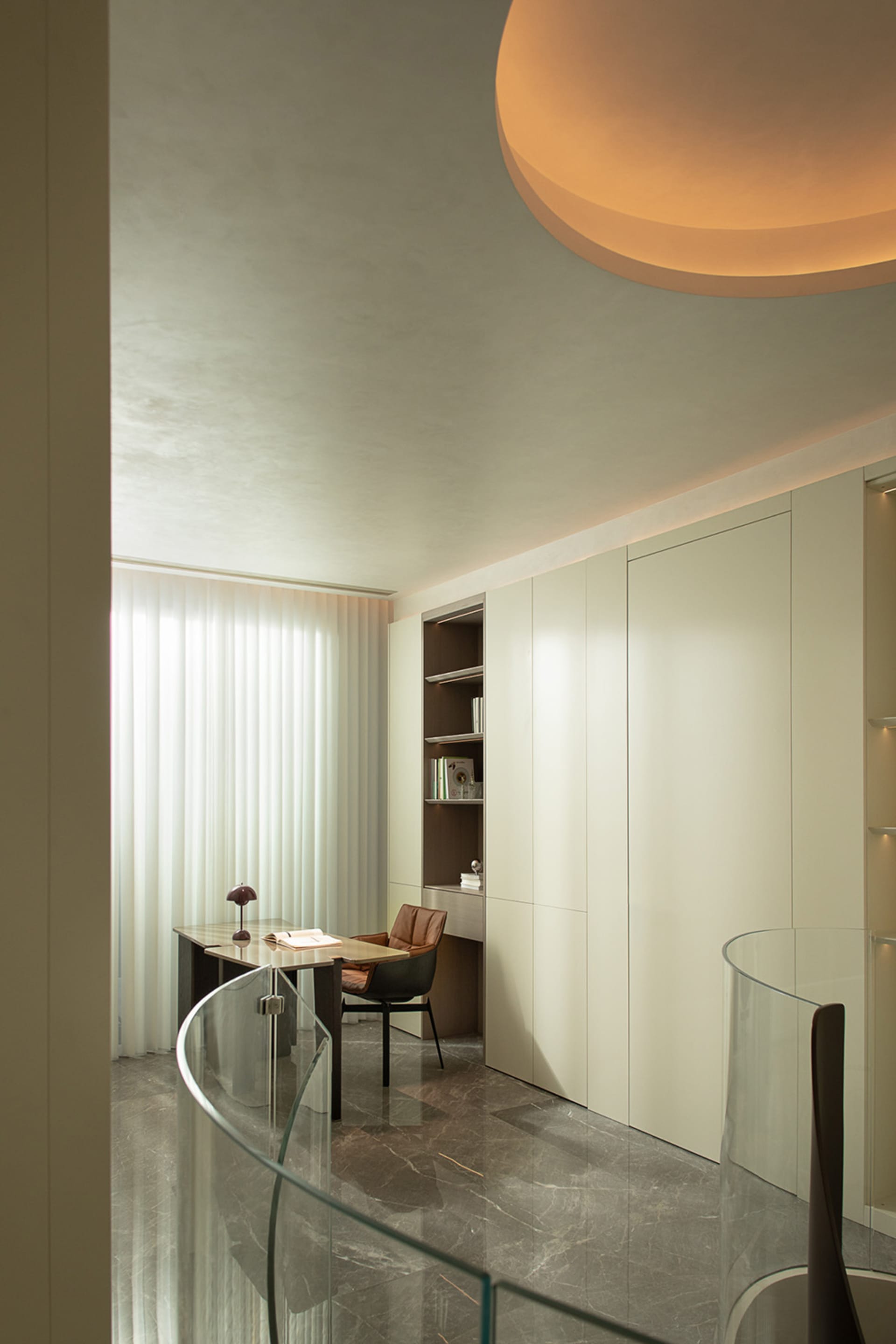 A modern study room featuring a marble floor, minimalistic design, and a comfortable working space.