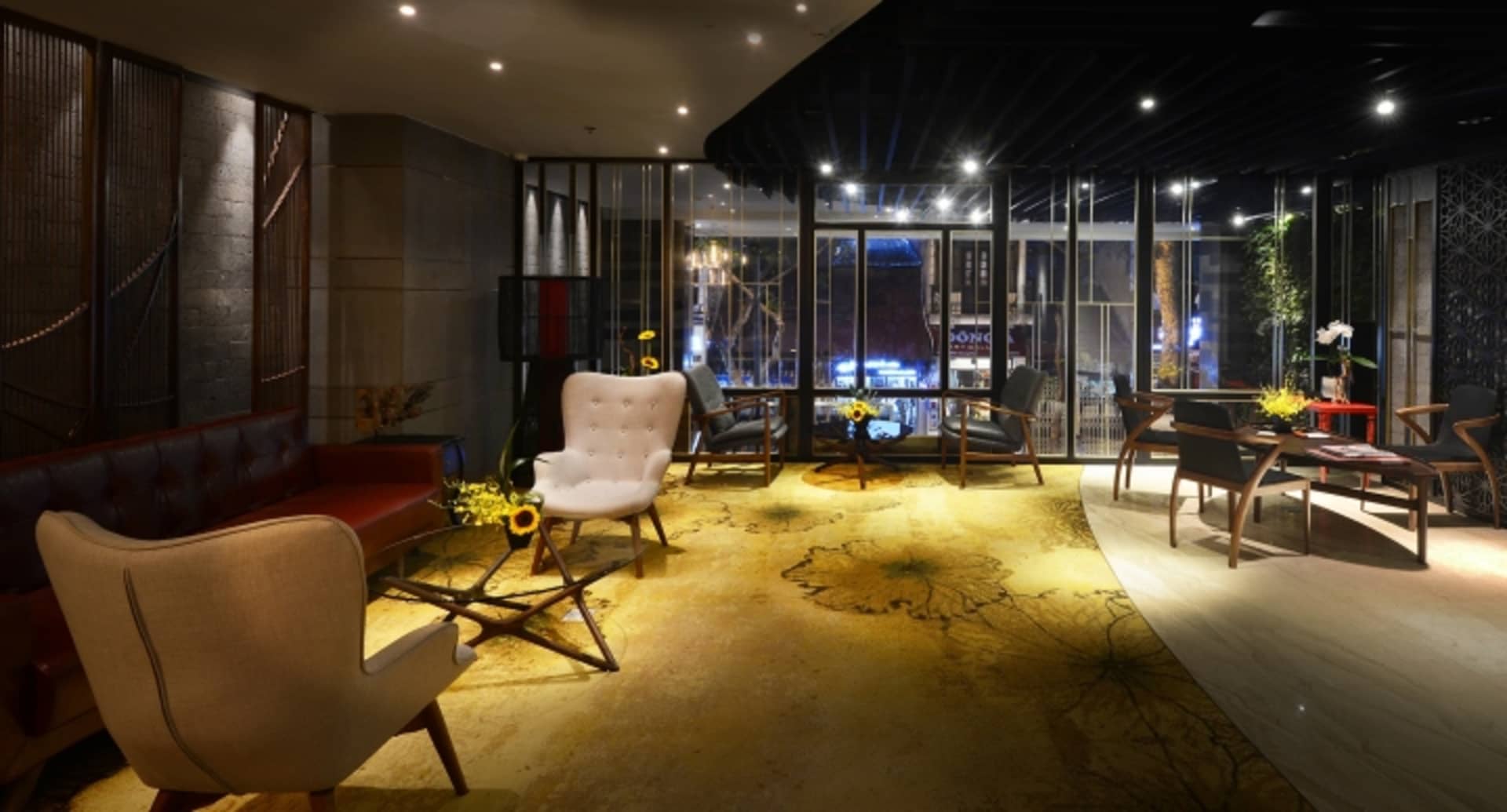 A stylish lobby with concrete flooring, industrial design elements, and modern seating