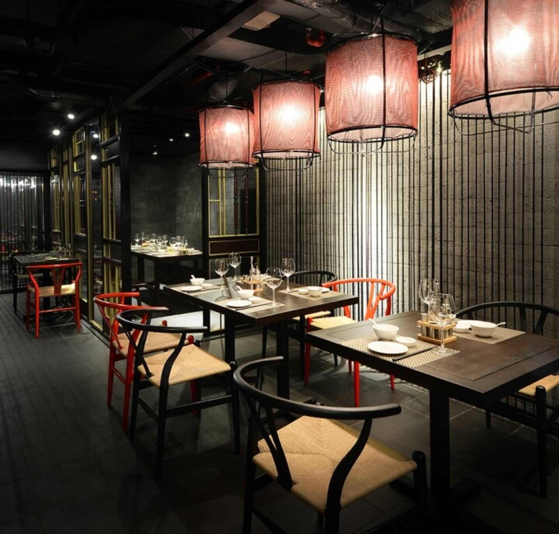 工業風格的餐廳室內,配有木質座椅、布料燈具以及金屬元素。