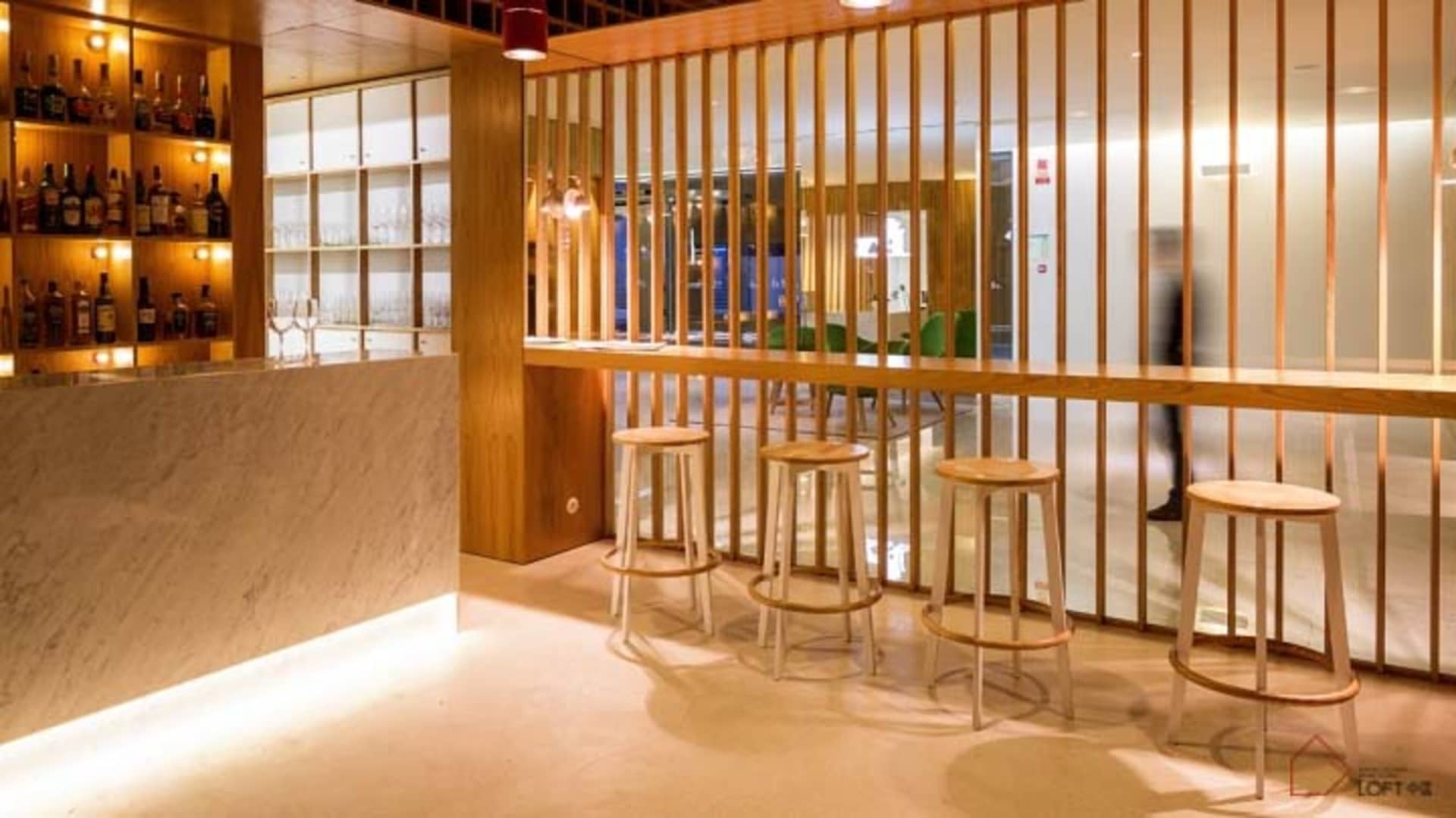 現代工業風餐廳吧台,搭配木質吧凳與木質隔屏。