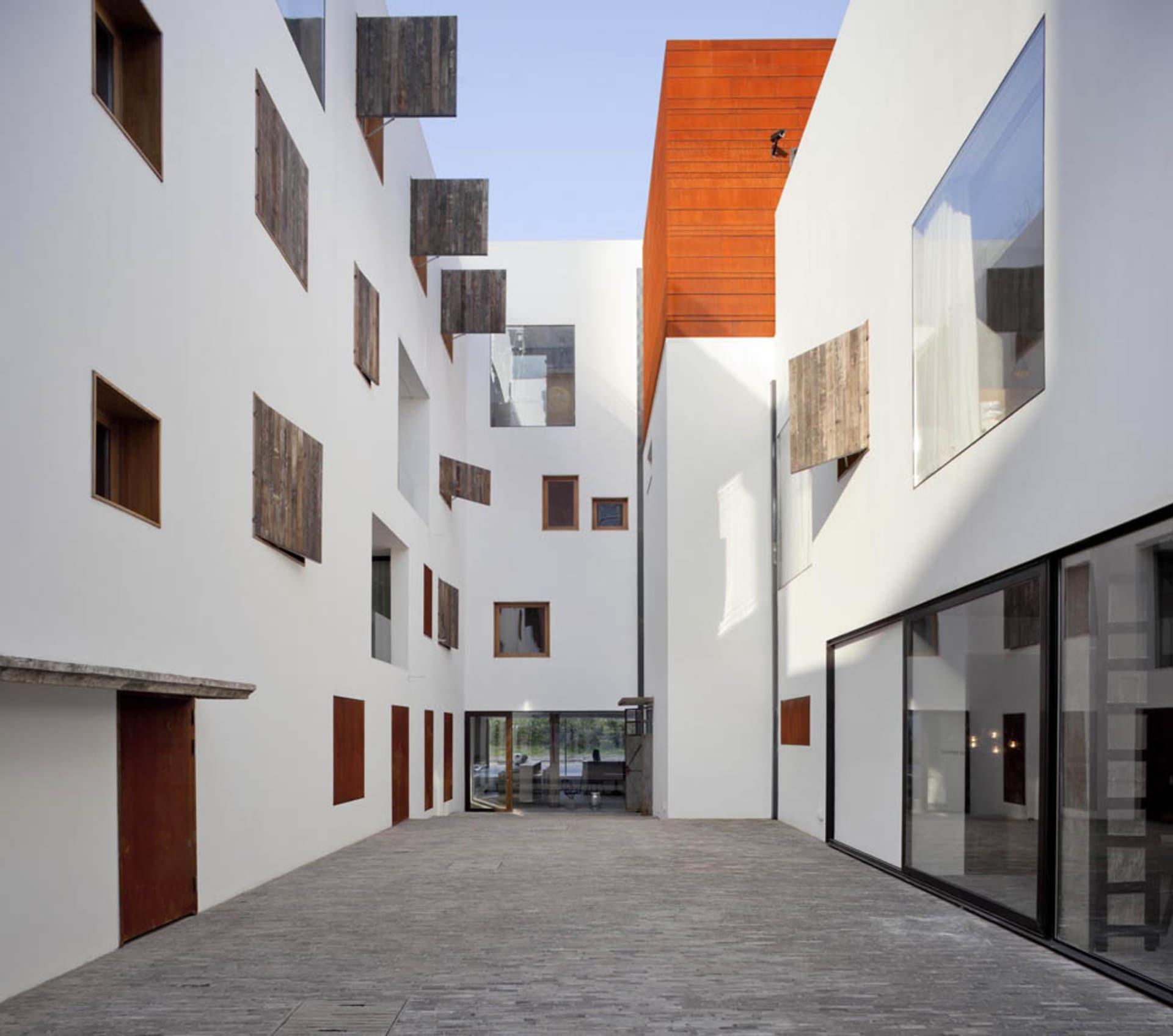 Modern architectural design featuring a glass facade and white walls.