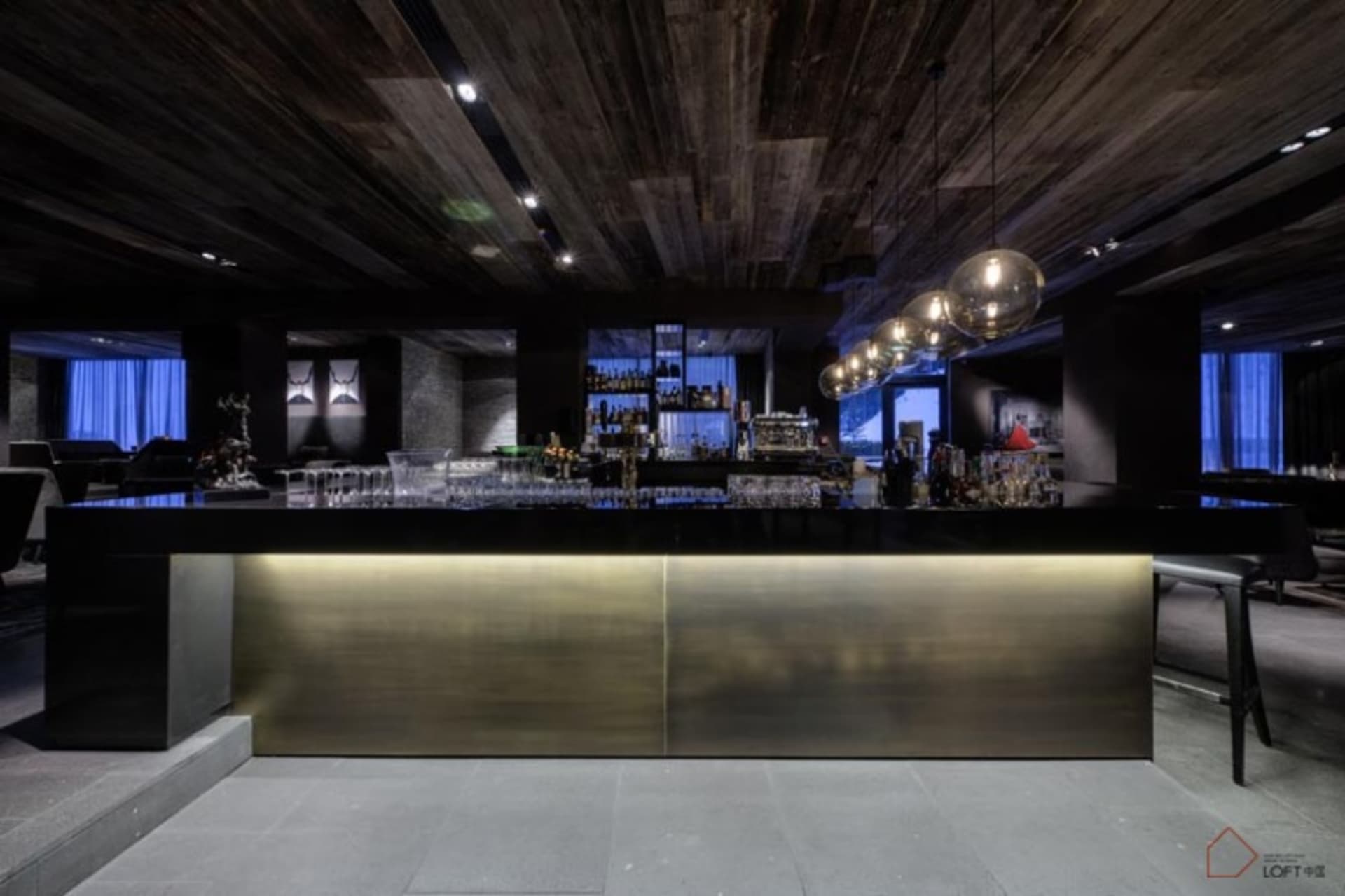 A modern bar with wooden elements and a sleek, minimalist design.