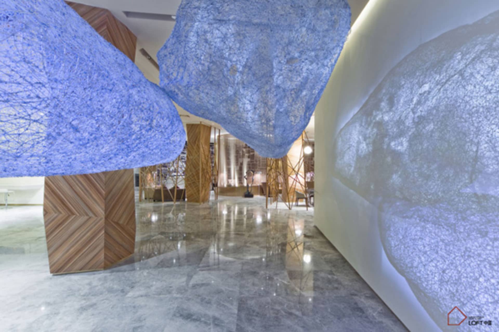 A modern luxury lobby featuring textured glass panels and fiber installations.