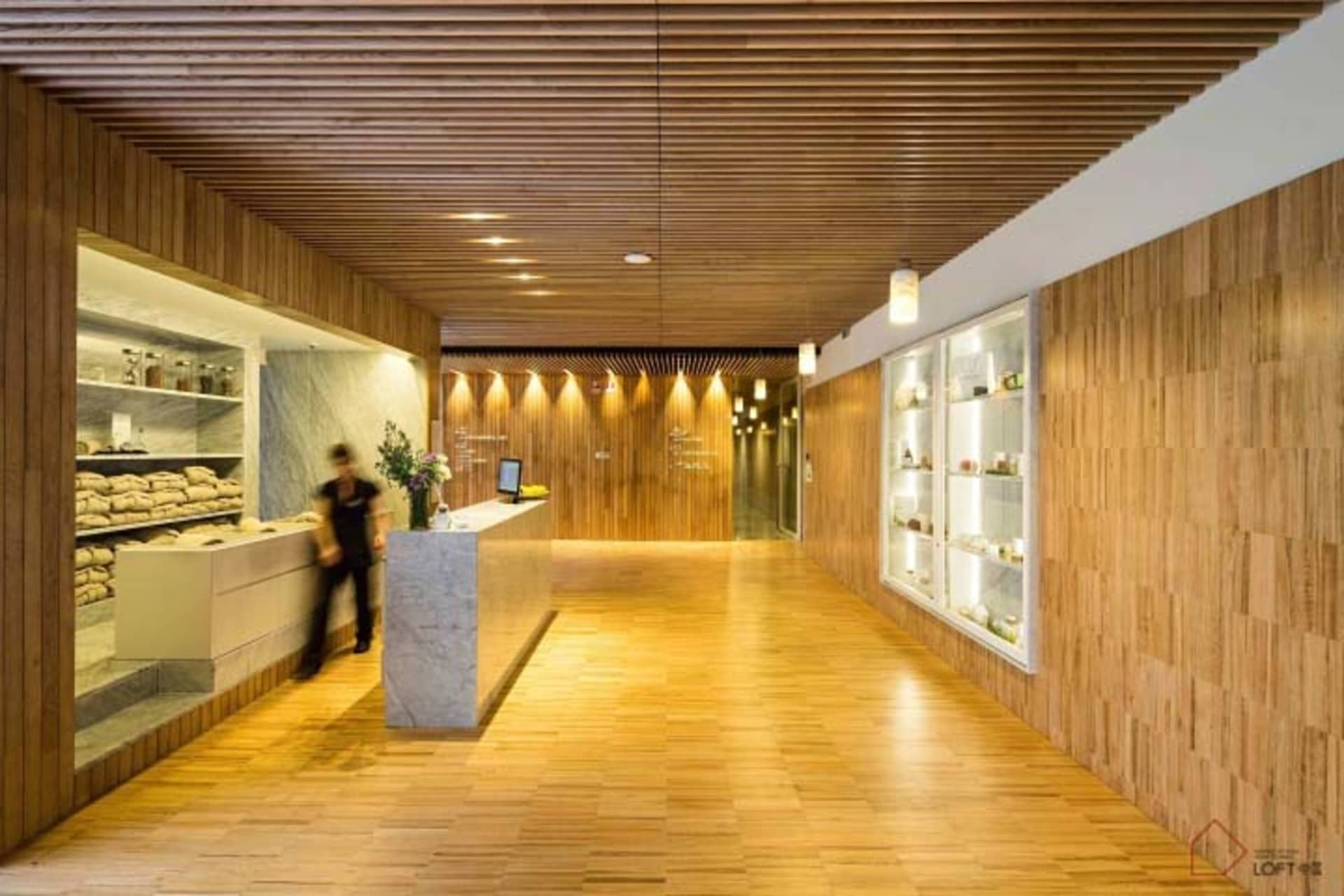 Modern reception desk with a wood finish in a well-lit office space.