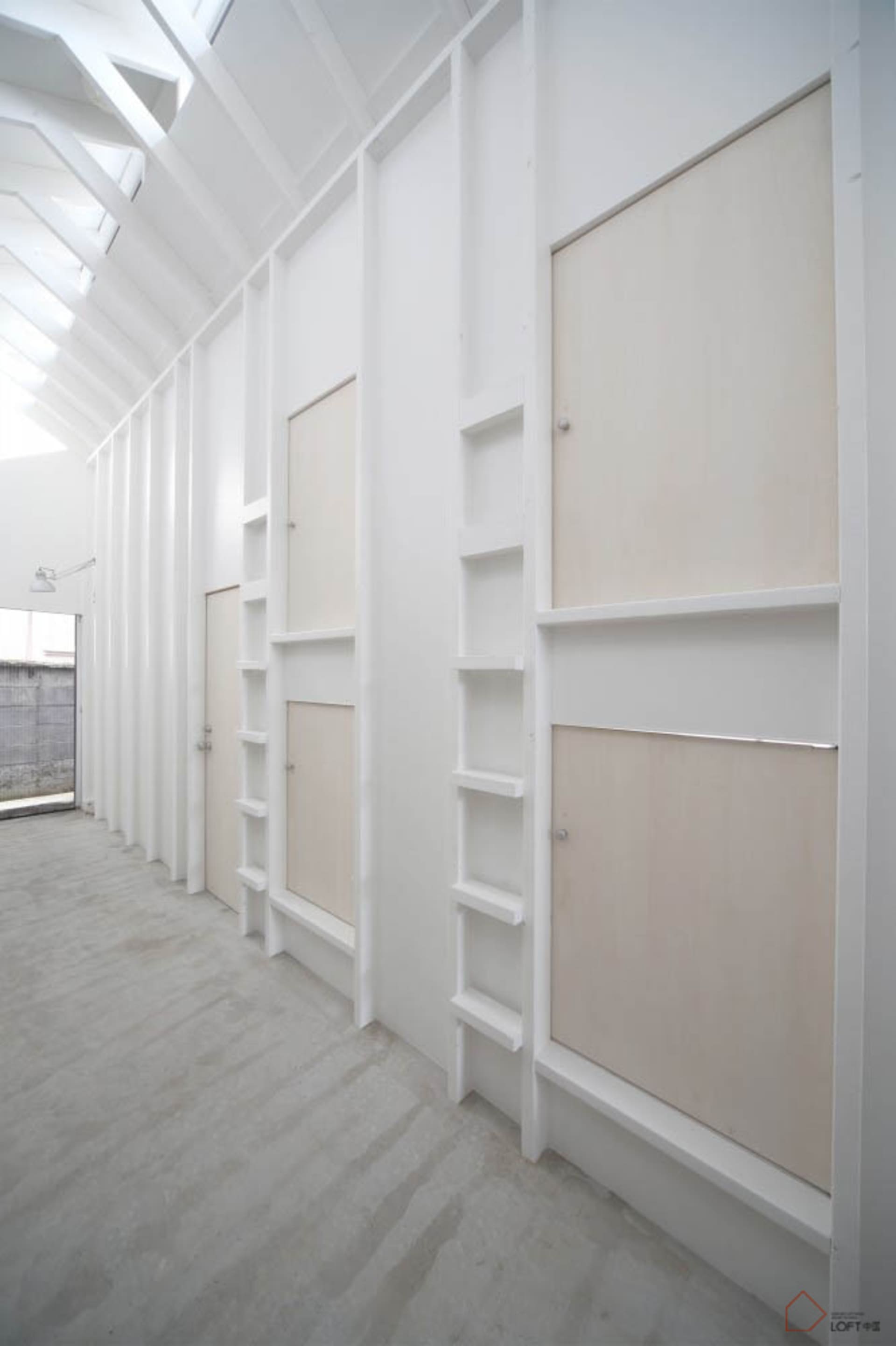 A minimalist bedroom with a concrete floor and walls.