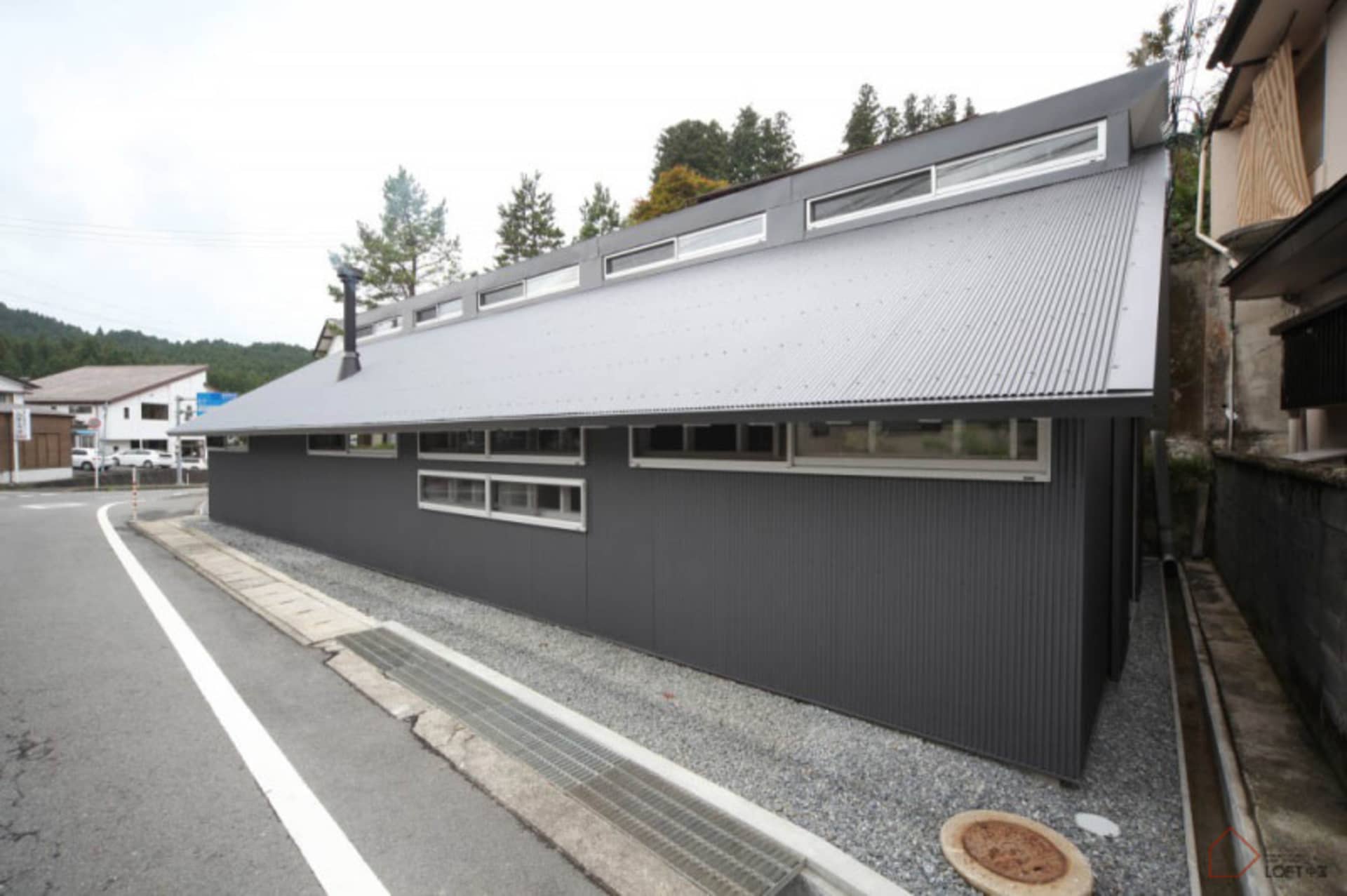 現代住宅建築，擁有金屬牆面與大型懸挑屋頂。