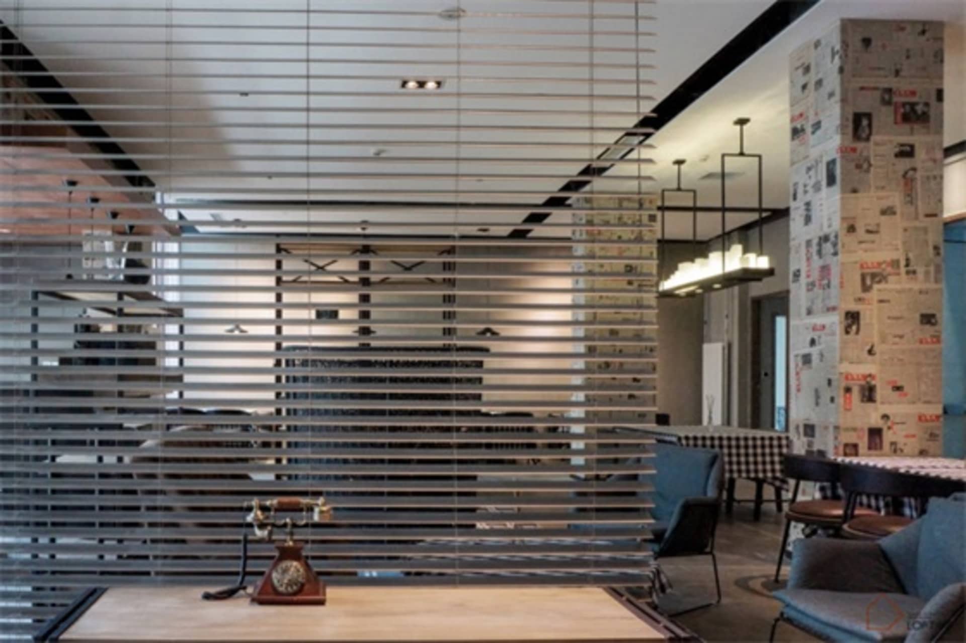 Metal counter with a vintage telephone on it in an industrial-themed cafe setting.