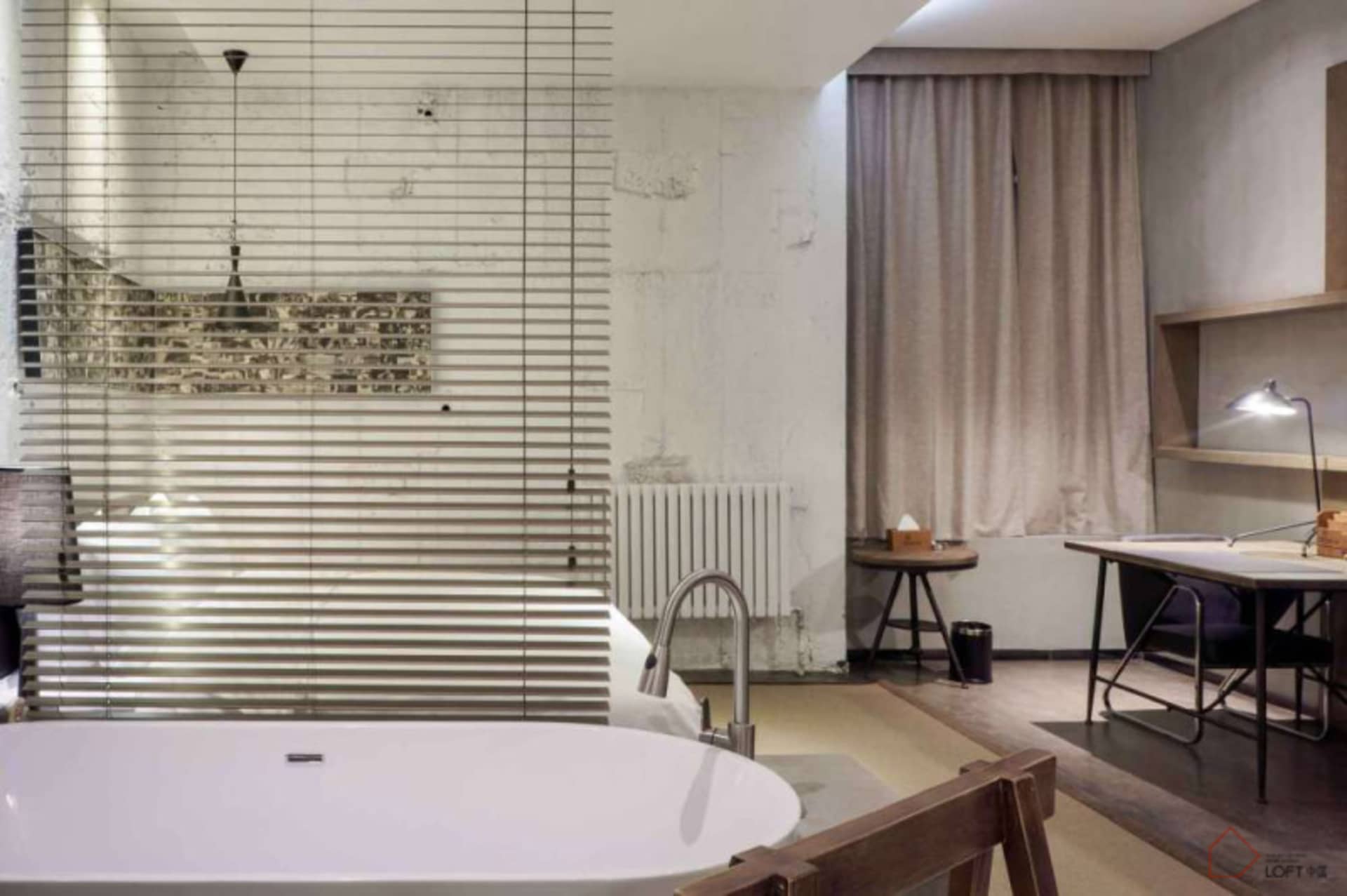 A minimalist modern bathroom with a freestanding bathtub made of concrete.