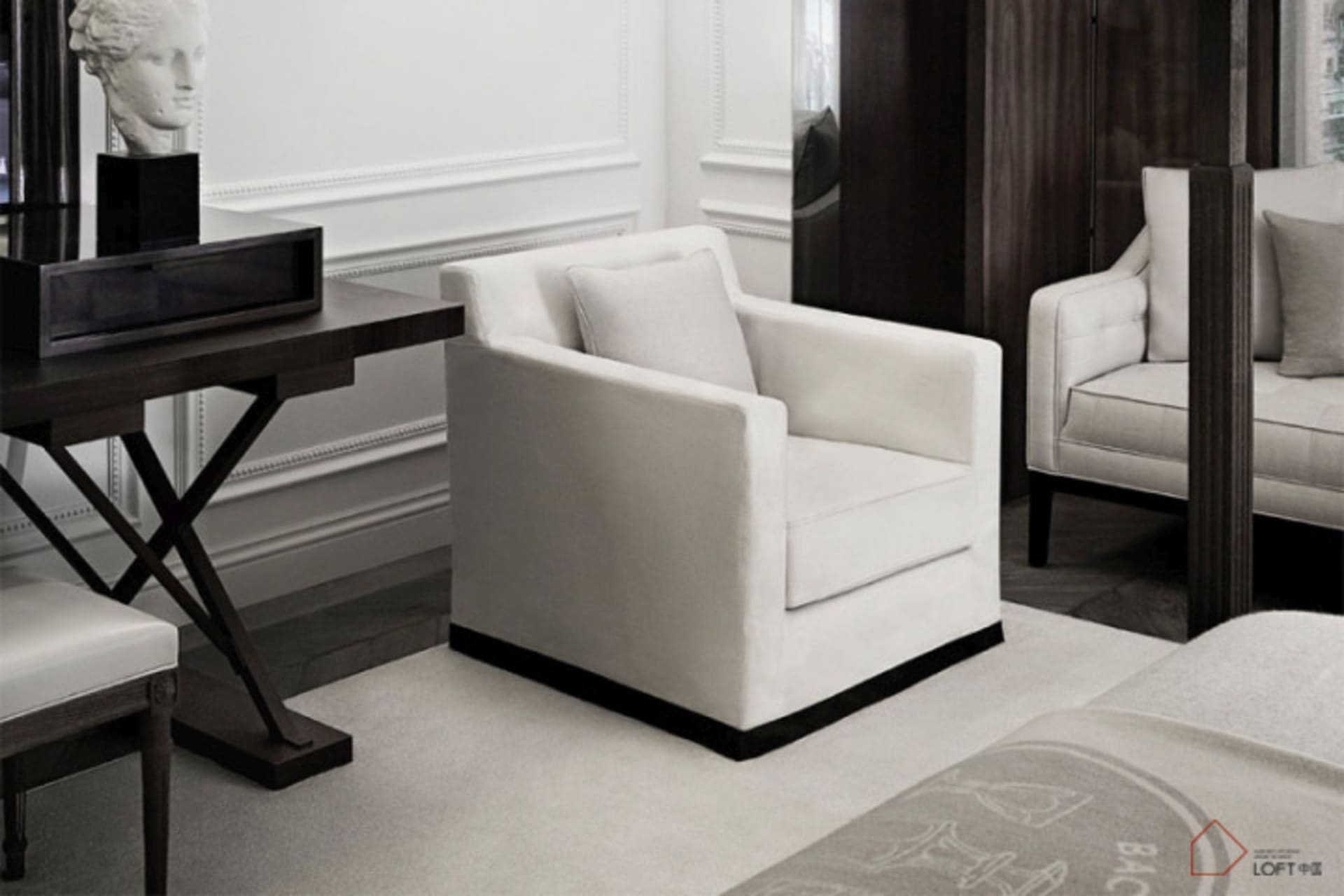 A modern bedroom featuring a white upholstered armchair with textured fabric, placed against a minimalist backdrop with a con