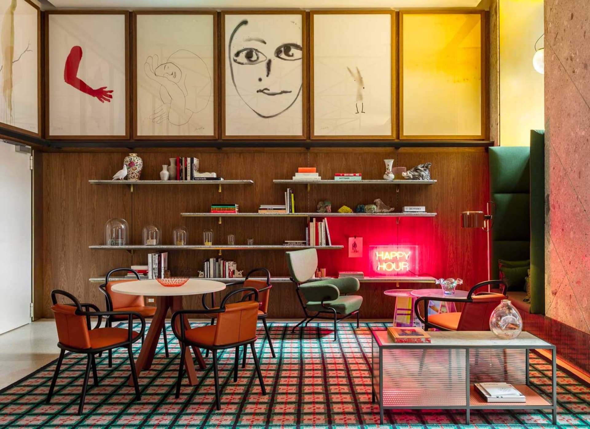 A modern cafe bar interior with a mix of materials and colorful elements, featuring a round table, chairs, shelves, and a neo