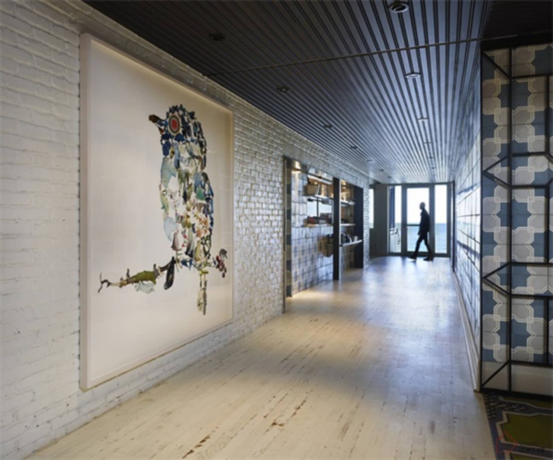 現代室內空間，磚牆搭配混凝土地板，陳列大型抽象藝術作品。