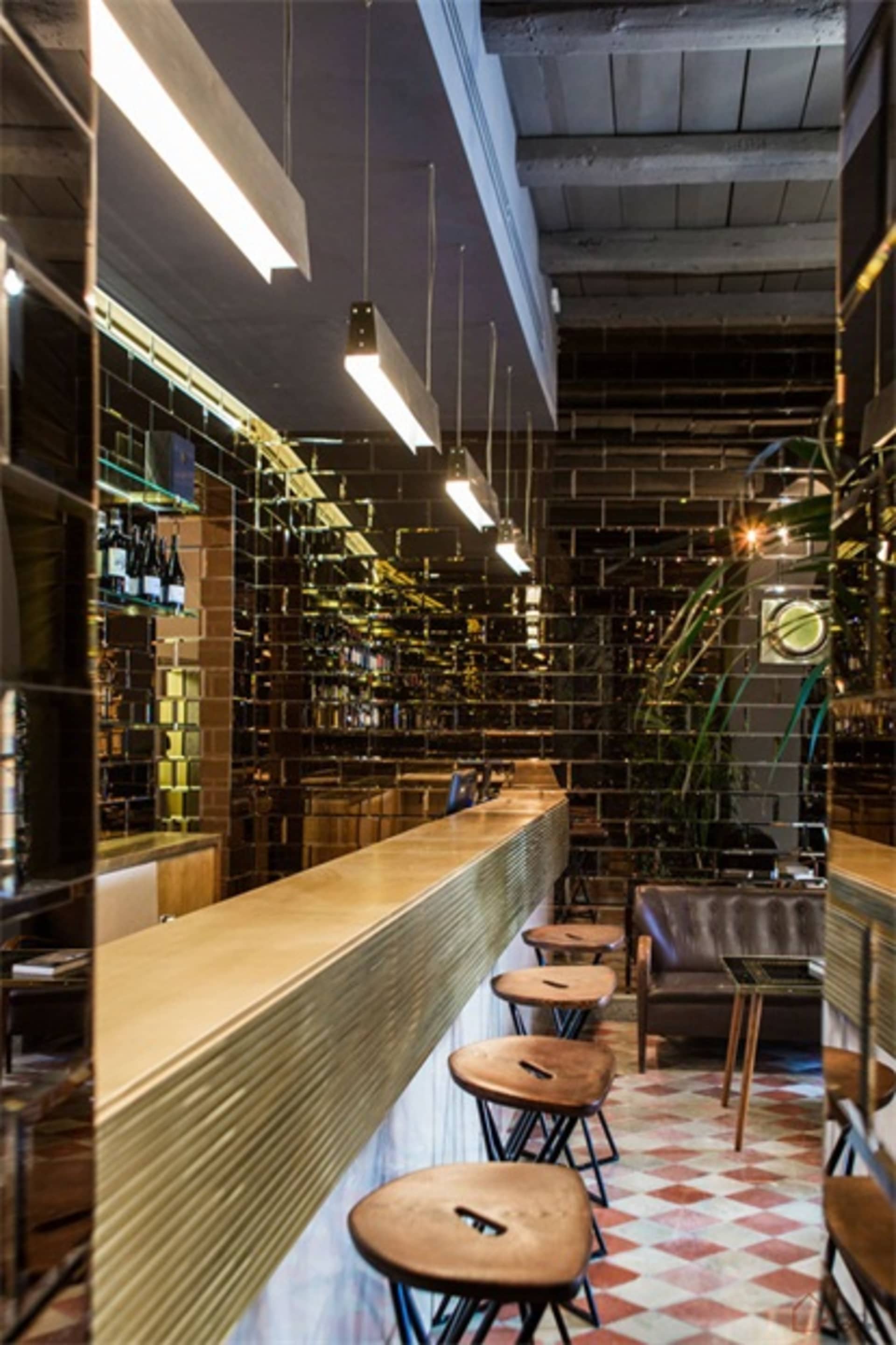 現代工業風餐酒吧室內視圖，裸露磚牆與拋光混凝土吧台。