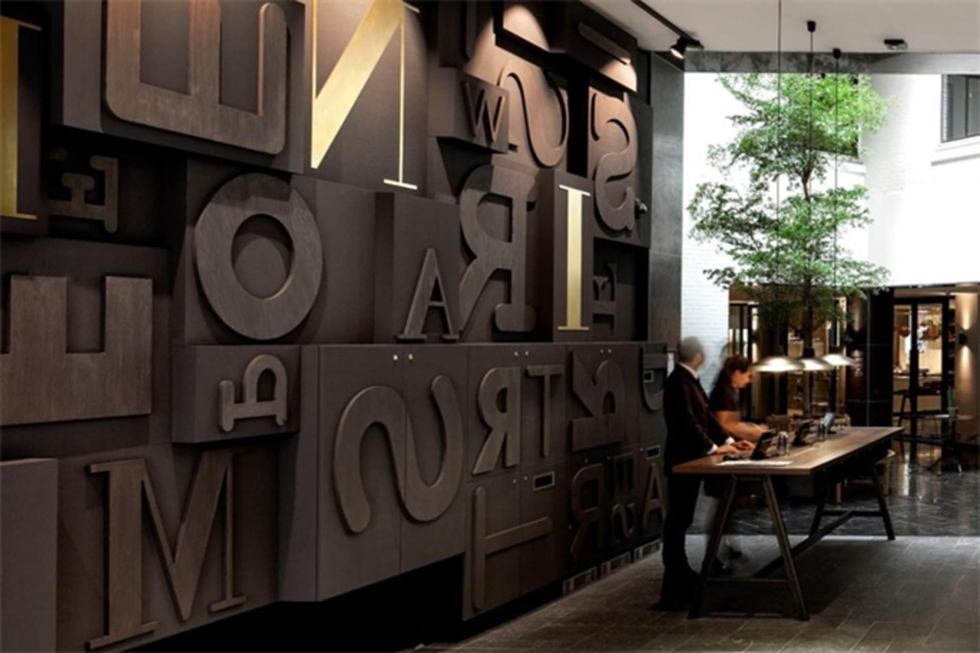Industrial-style lobby featuring a large, modern metal wall sculpture.