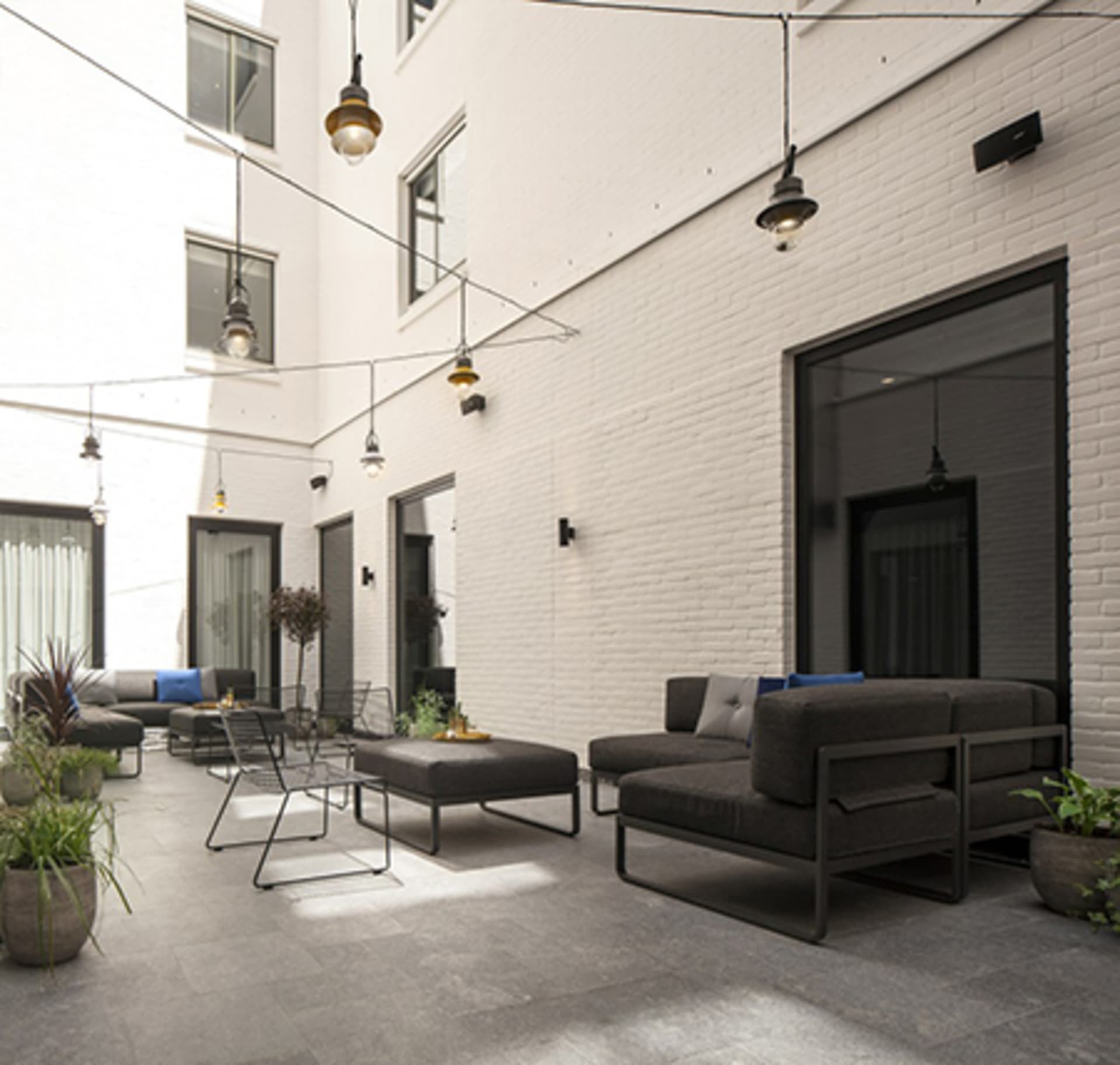 Industrial outdoor lounge area with concrete flooring and seating.