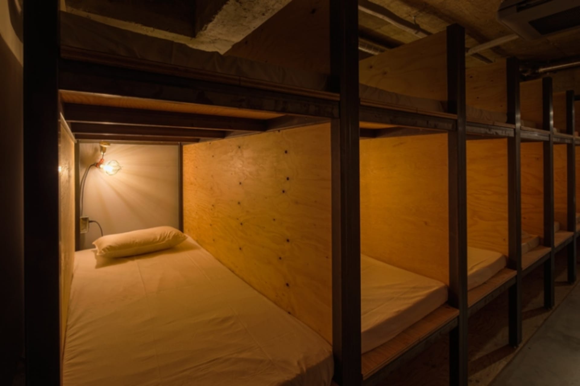 Modern minimalist bedroom with wood paneling and a single bed.