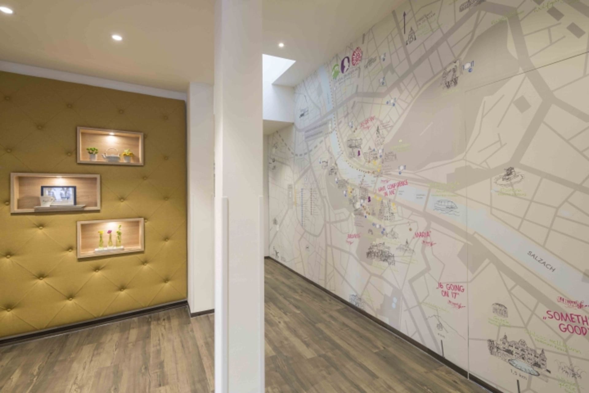 An office space featuring a large, detailed city map displayed on the wall, with decorative shelving units mounted on the adj