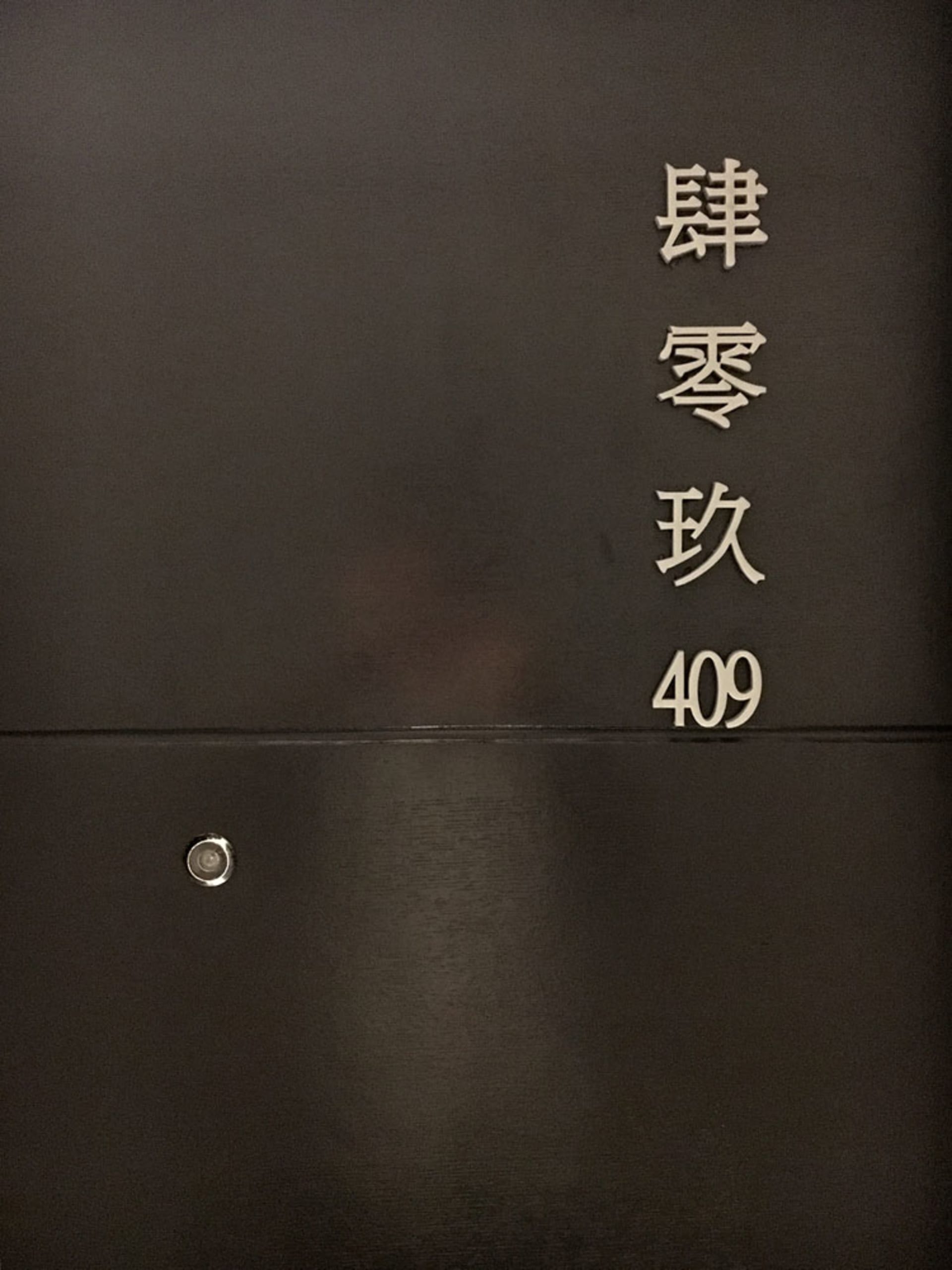 黑色金屬門，門上標有 409 號碼，門楣上方有中文字符。