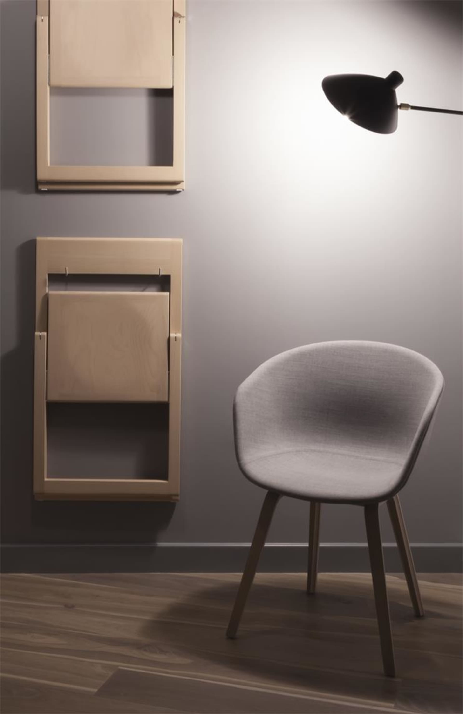 Modern minimalist interior design with a fabric chair and foldable chairs on the wall.