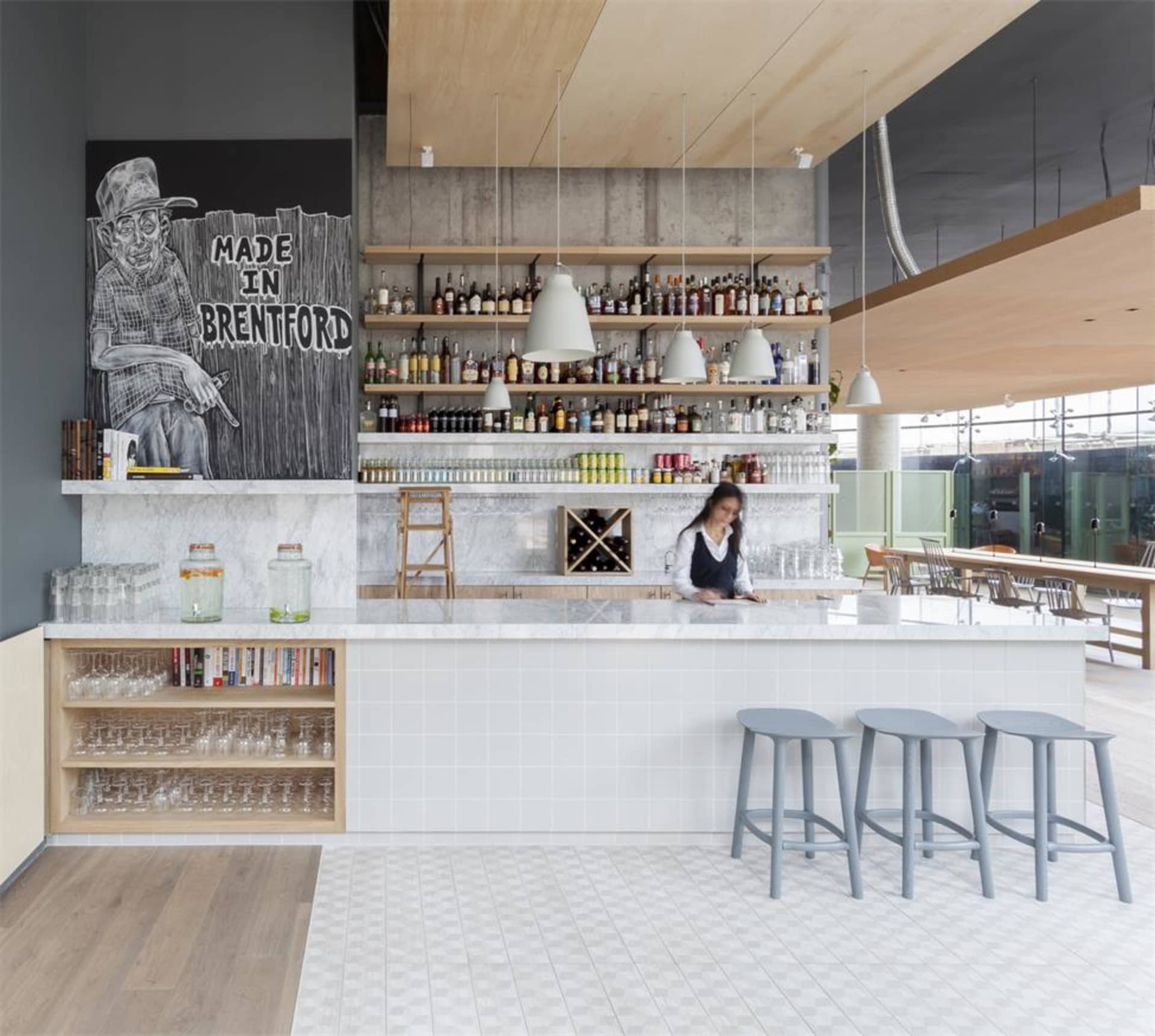 Modern restaurant bar interior with marble countertops, concrete walls, and hanging pendant lights