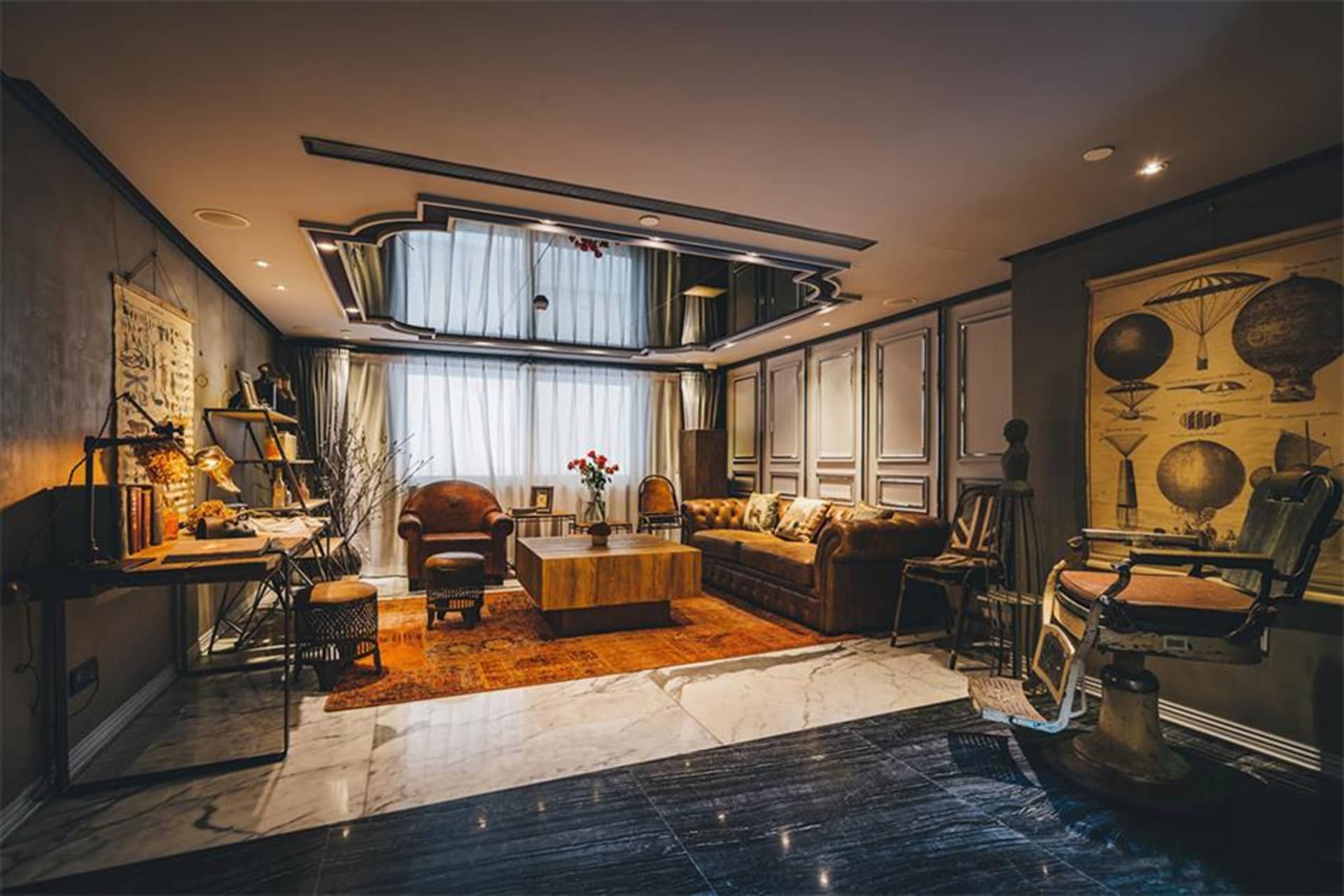 A modern, industrial-style living room featuring metal and wood furniture, exposed brick walls, and large windows with city v