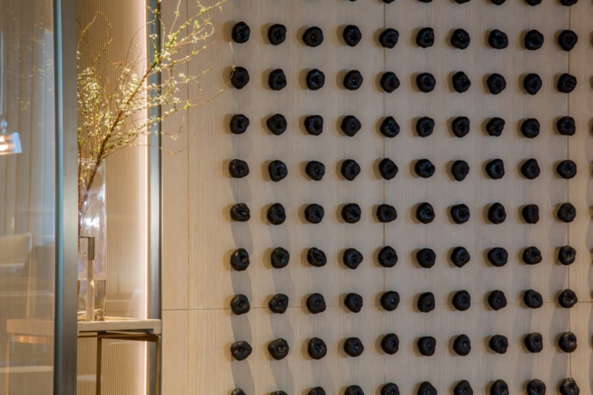Black spheres arranged on a textured wall in an interior design setting.