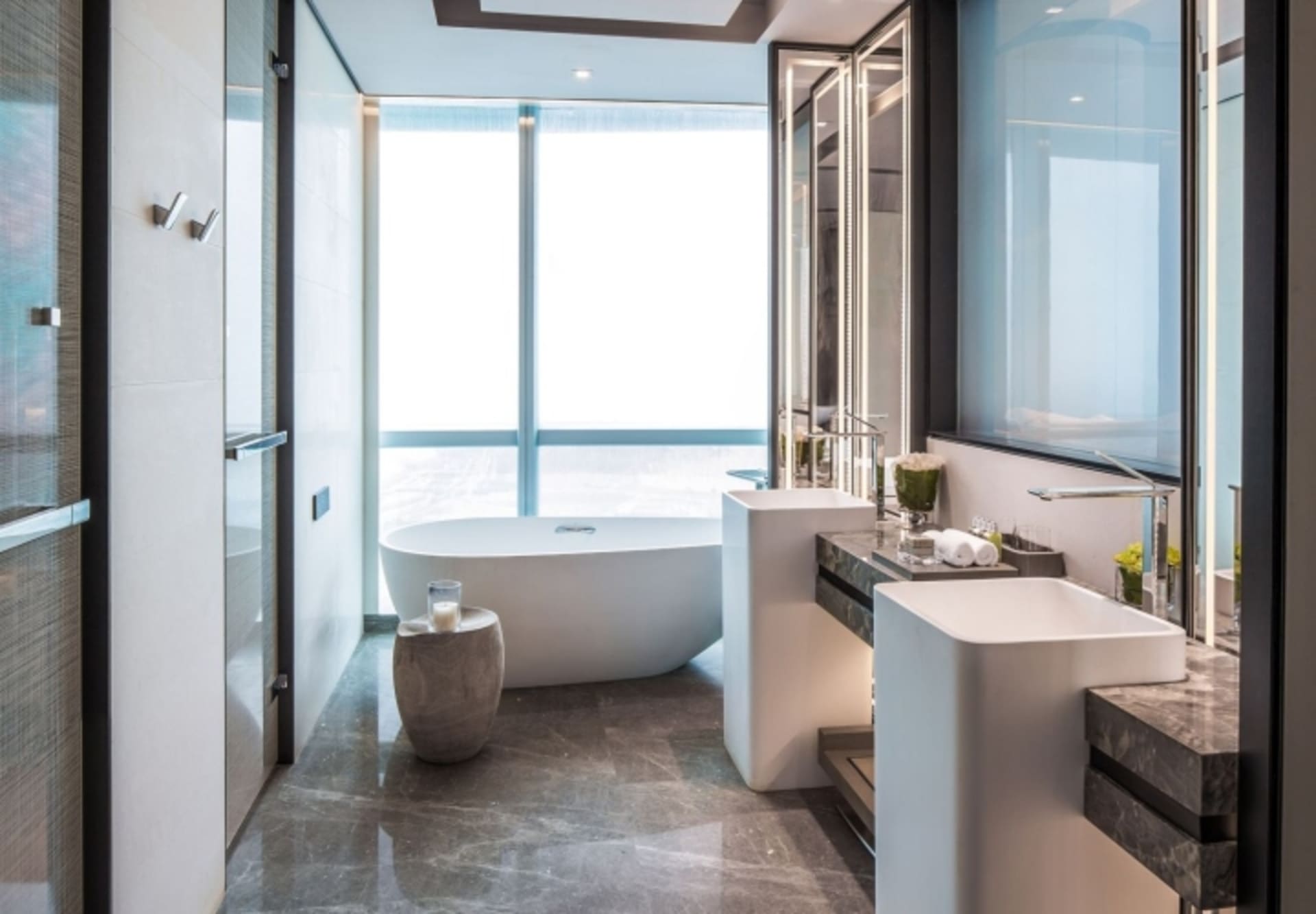 Modern bathroom featuring marble elements and featuring a spacious bathtub and double sinks.