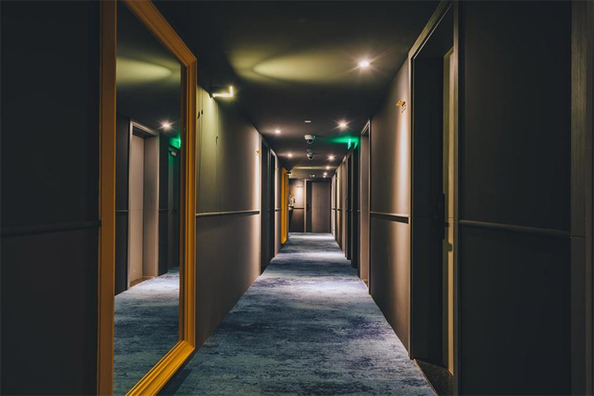 現代酒店內的長走廊，鋪設地毯並搭配嵌入式照明。