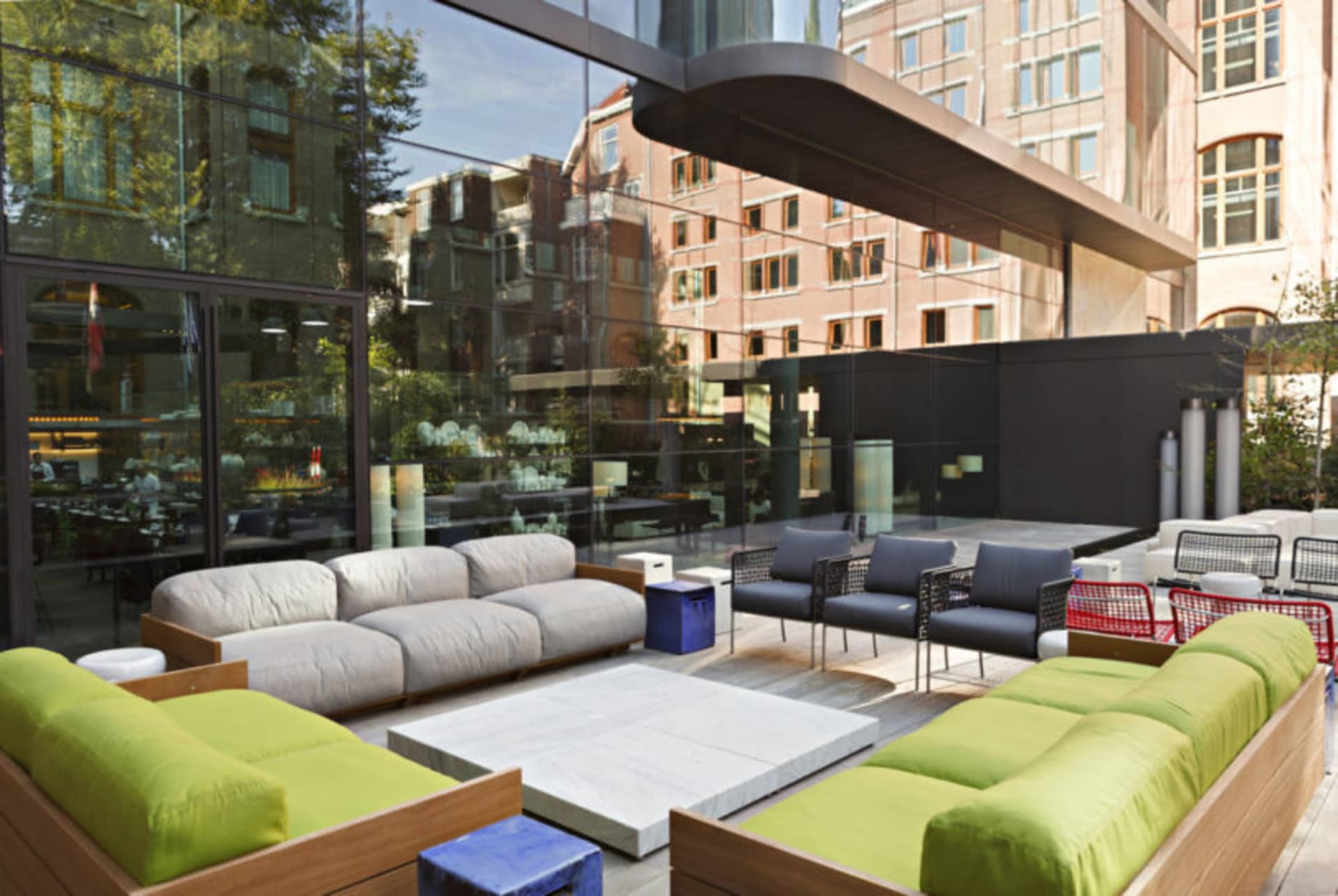 Modern outdoor lounge area with sofas, chairs, and tables.