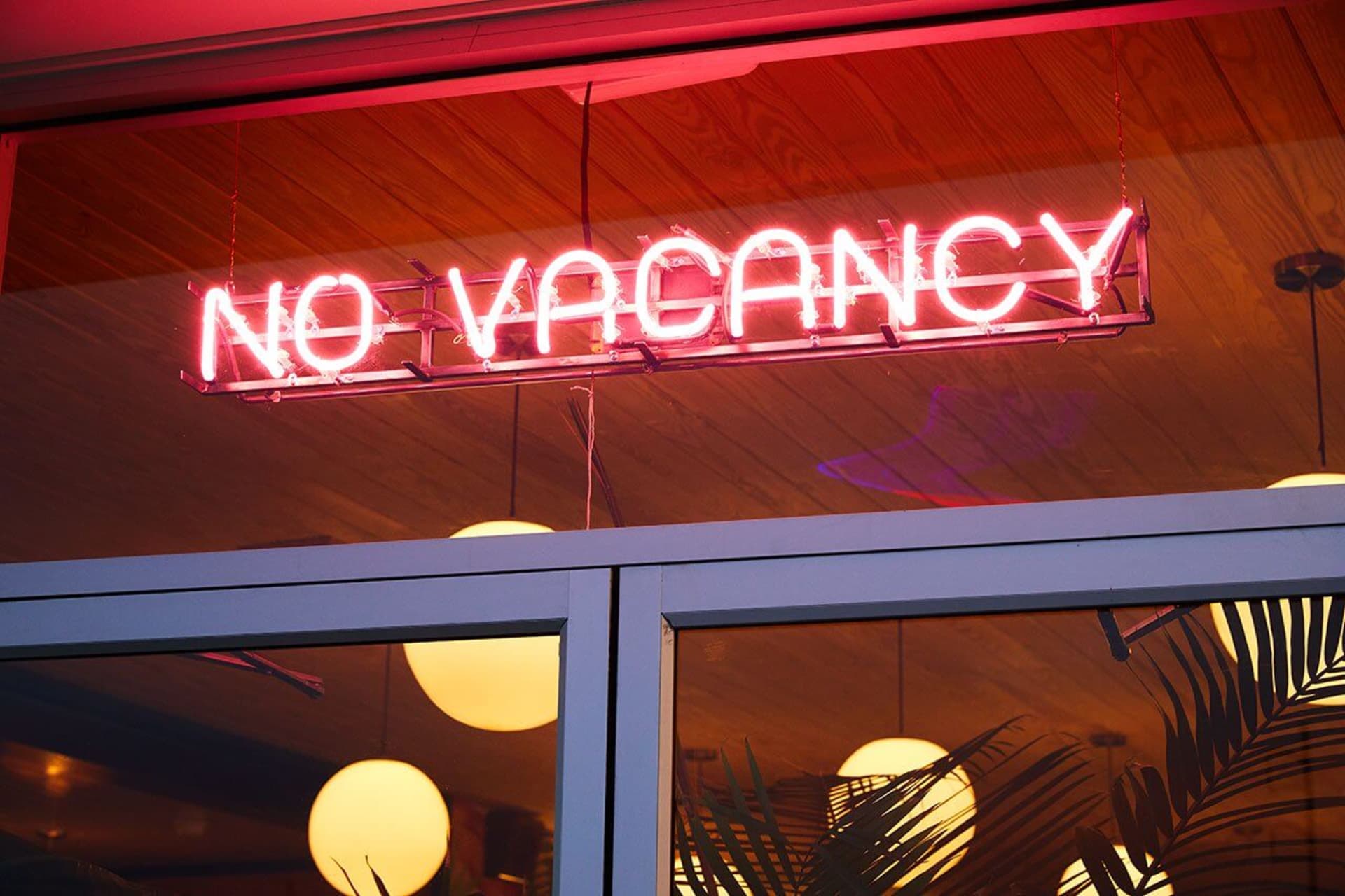 酒店或餐廳外掛著霓虹燈招牌，顯示「NO VACANCY」。