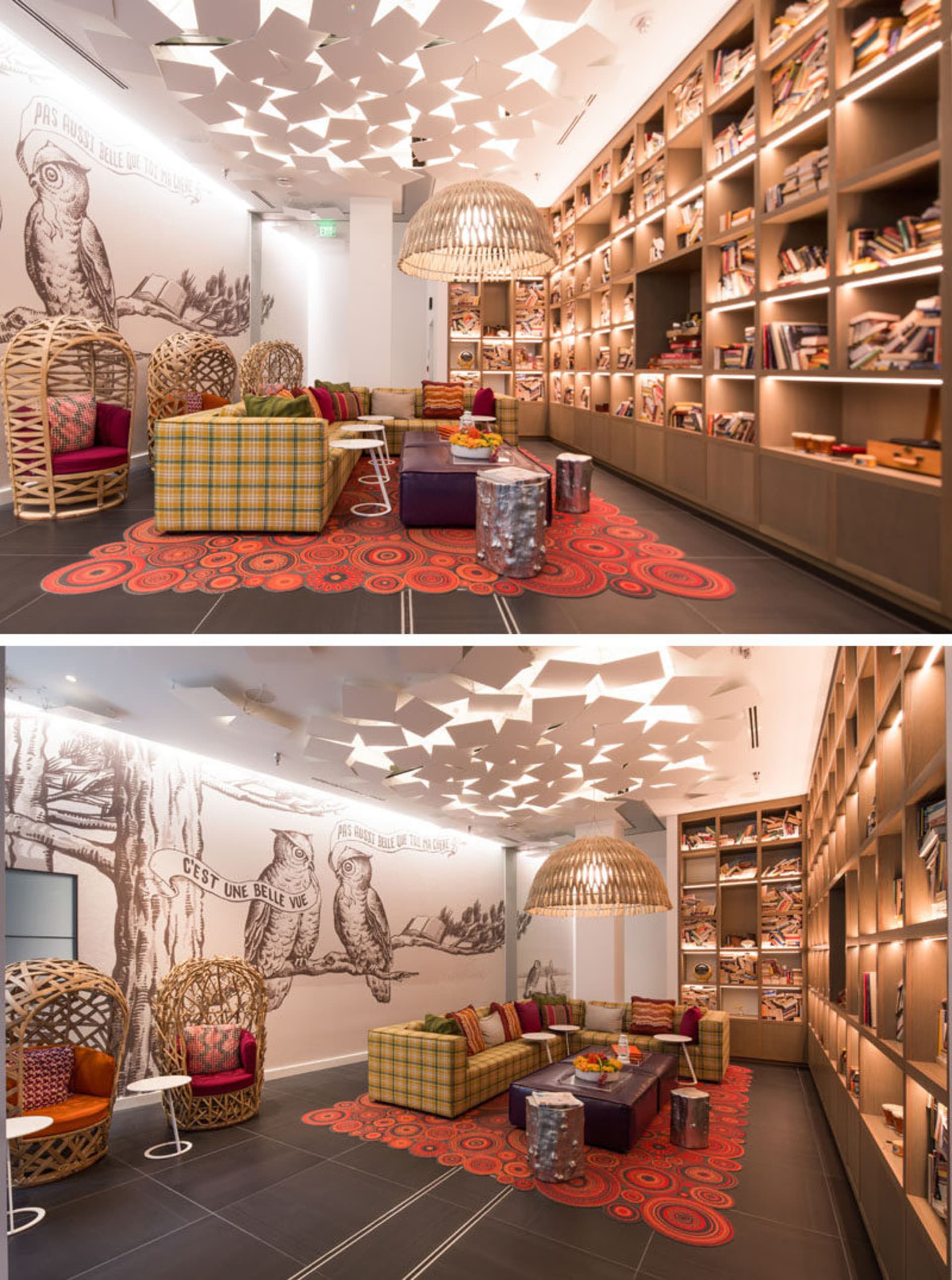 A modern library space with a ceiling adorned with paper shapes, wooden shelves filled with books, and a cozy seating area wi