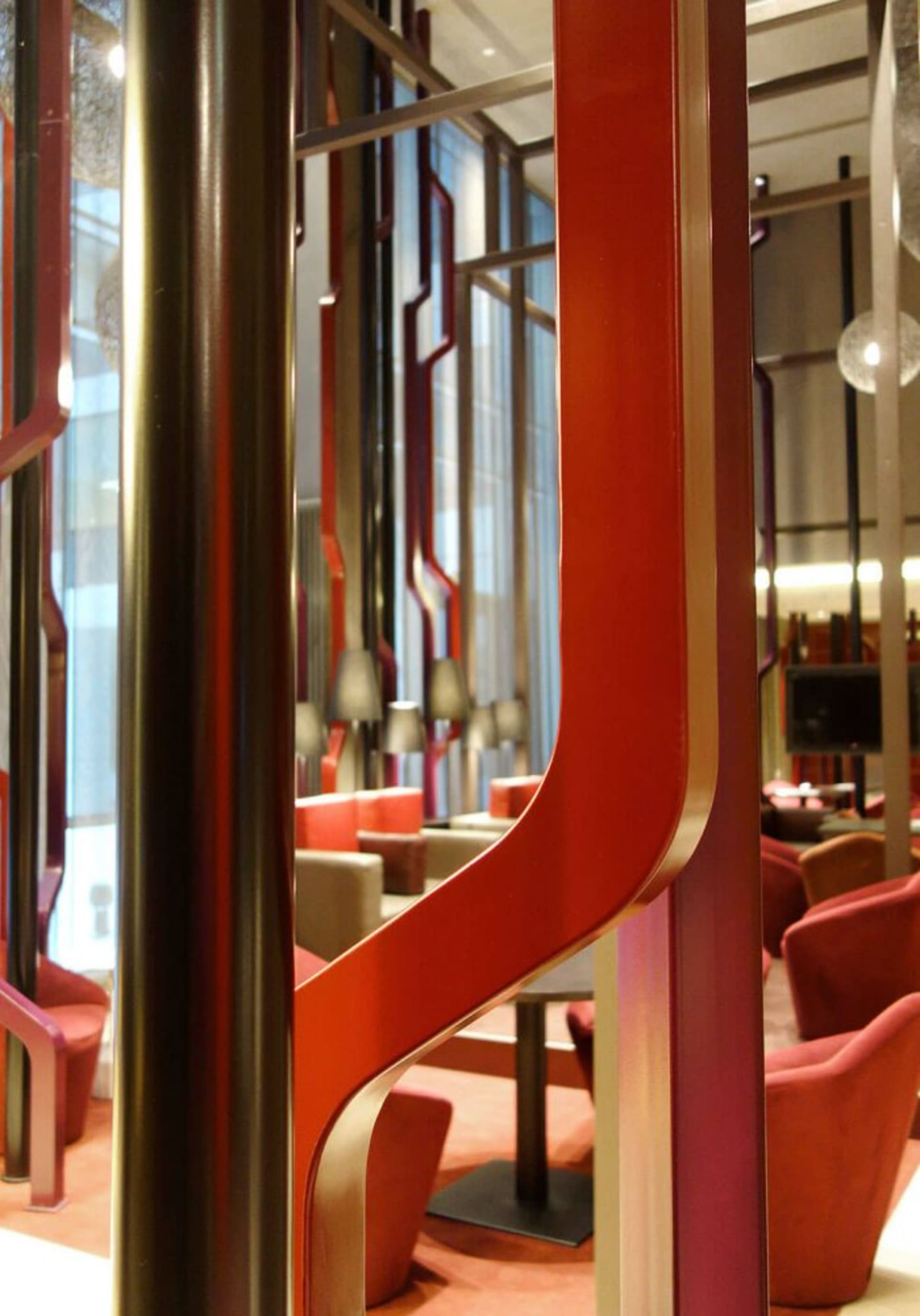 A modern lobby featuring sleek metallic columns and red acrylic elements