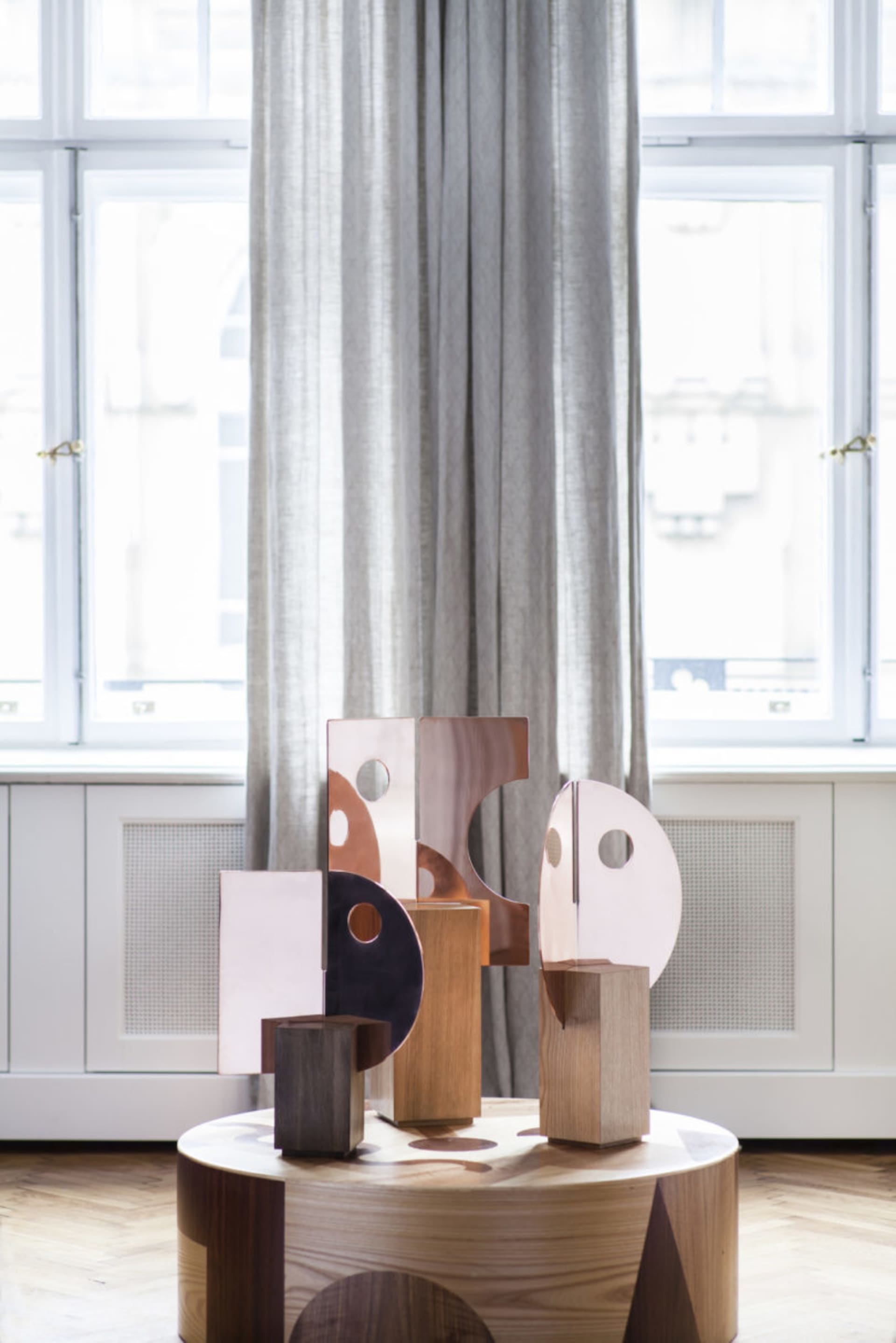 An abstract metal sculpture installation in an interior design setting.