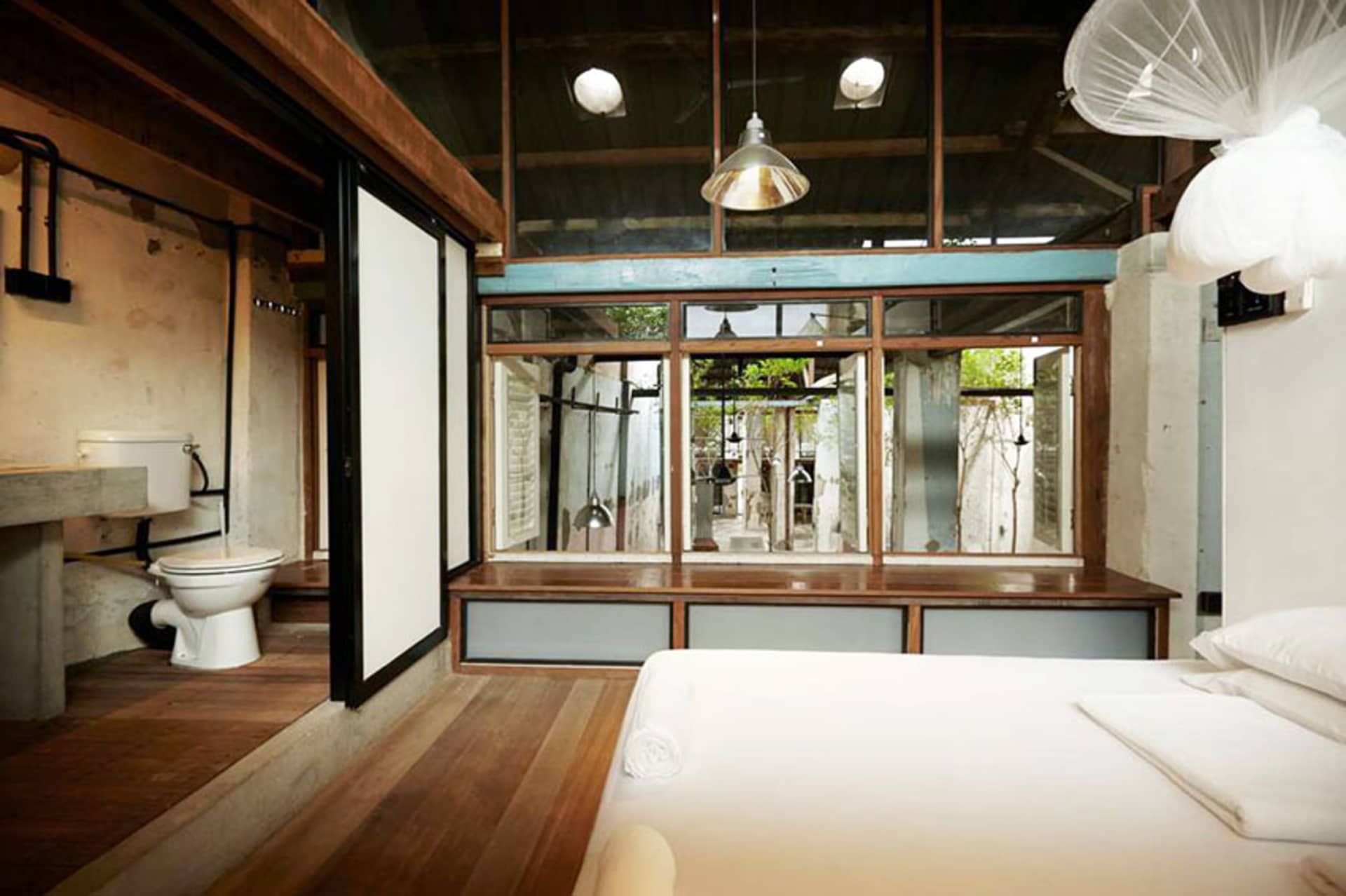 簡約臥室採用木質地板與家具，設有床鋪與衛浴區域。
