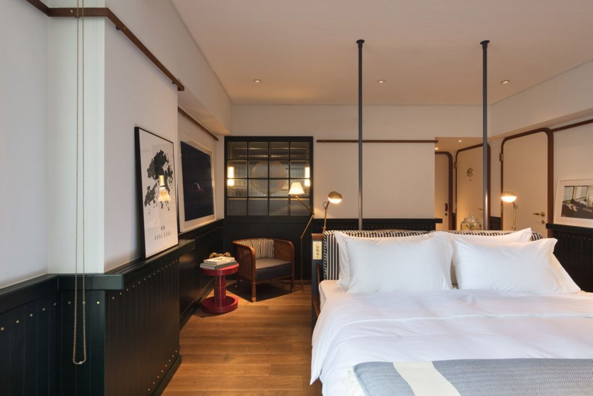 A modern bedroom featuring a wooden floor and concrete walls.