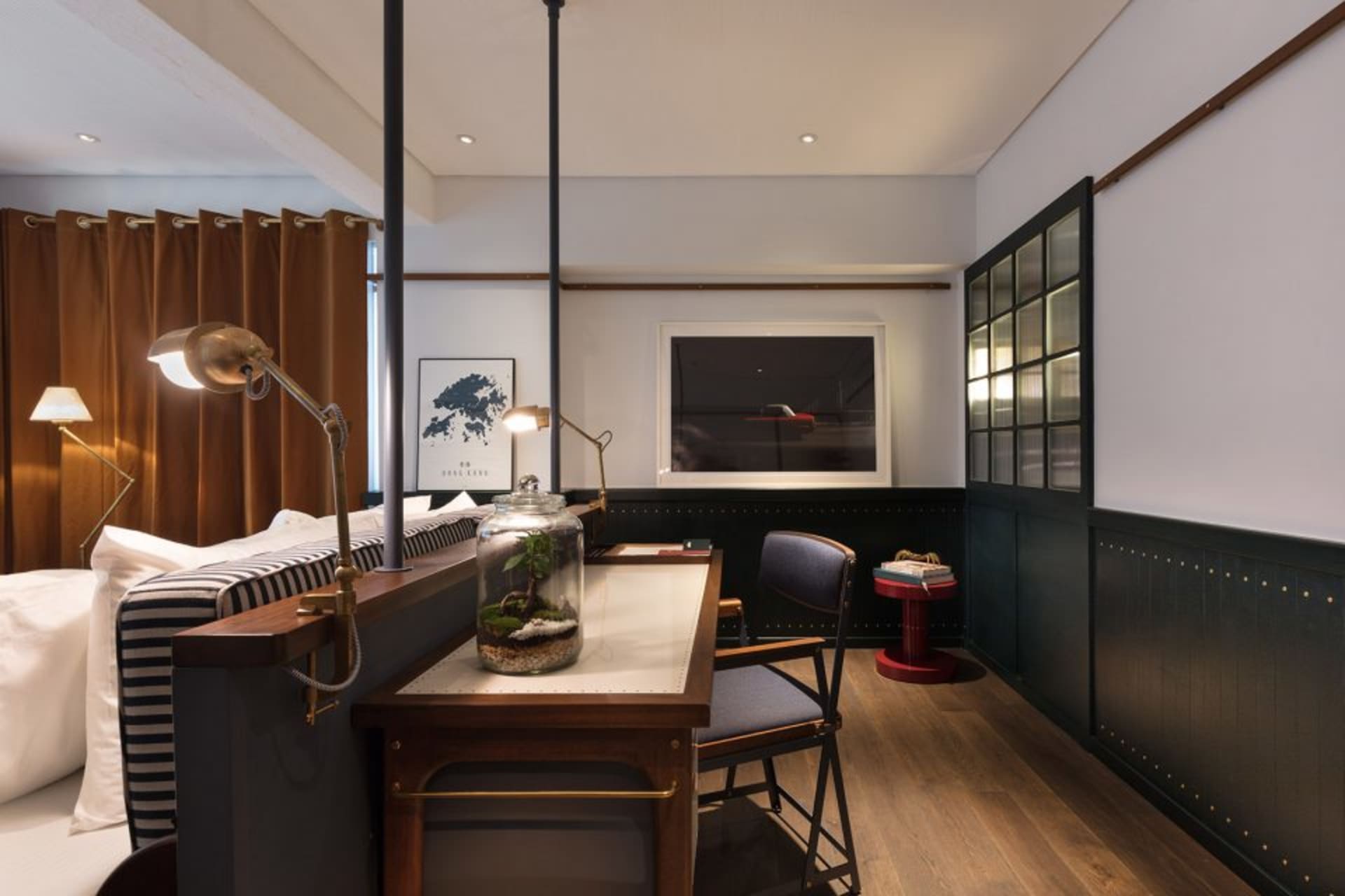 Modern home office space with a desk, chair, desk lamp, and framed picture, featuring wood and metal materials.