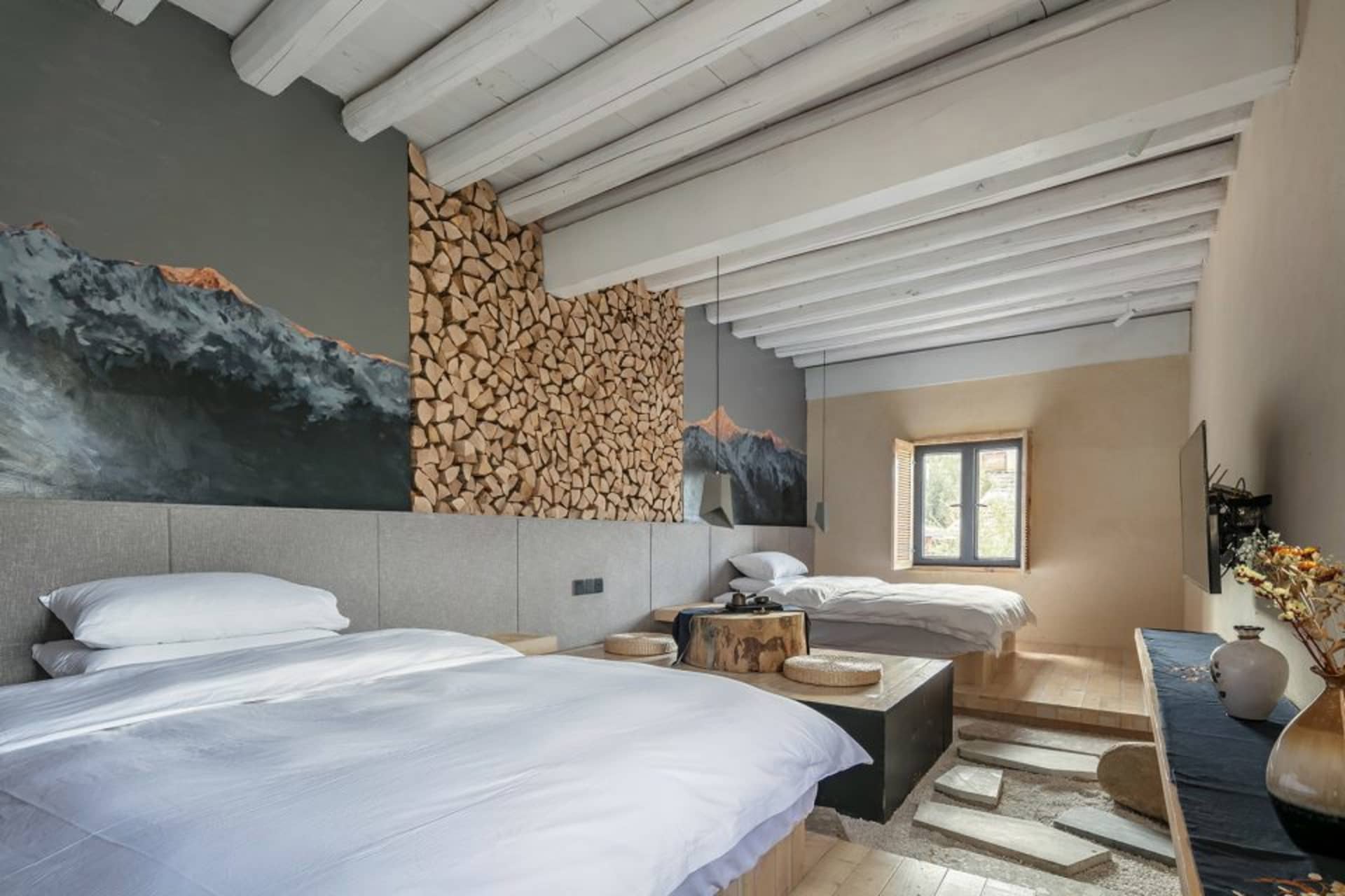 A modern traditional country bedroom with white bedding, wooden furniture, and a wooden ceiling.