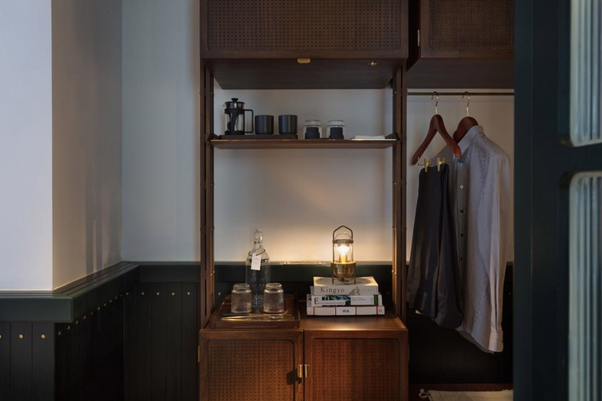 A modern wardrobe with dark wood shelves and clothing hanging inside.