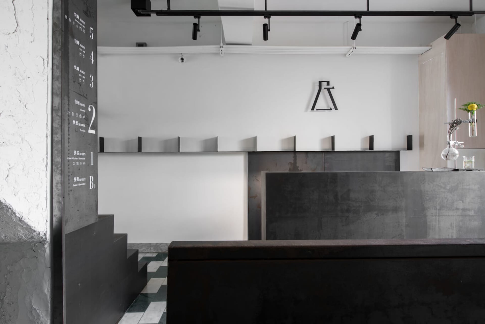 一間極簡工業風咖啡店,採用黑白配色,強調光滑的金屬與混凝土表面