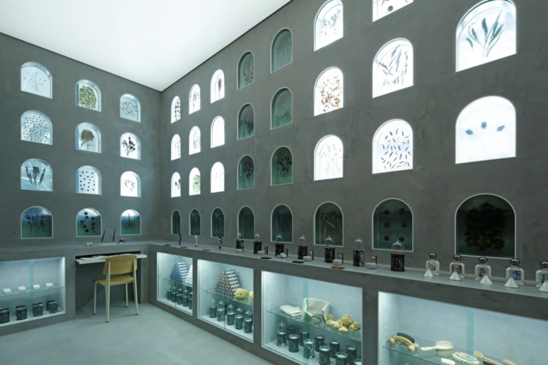 Industrial storefront with large glass windows, showcasing a collection of objects.