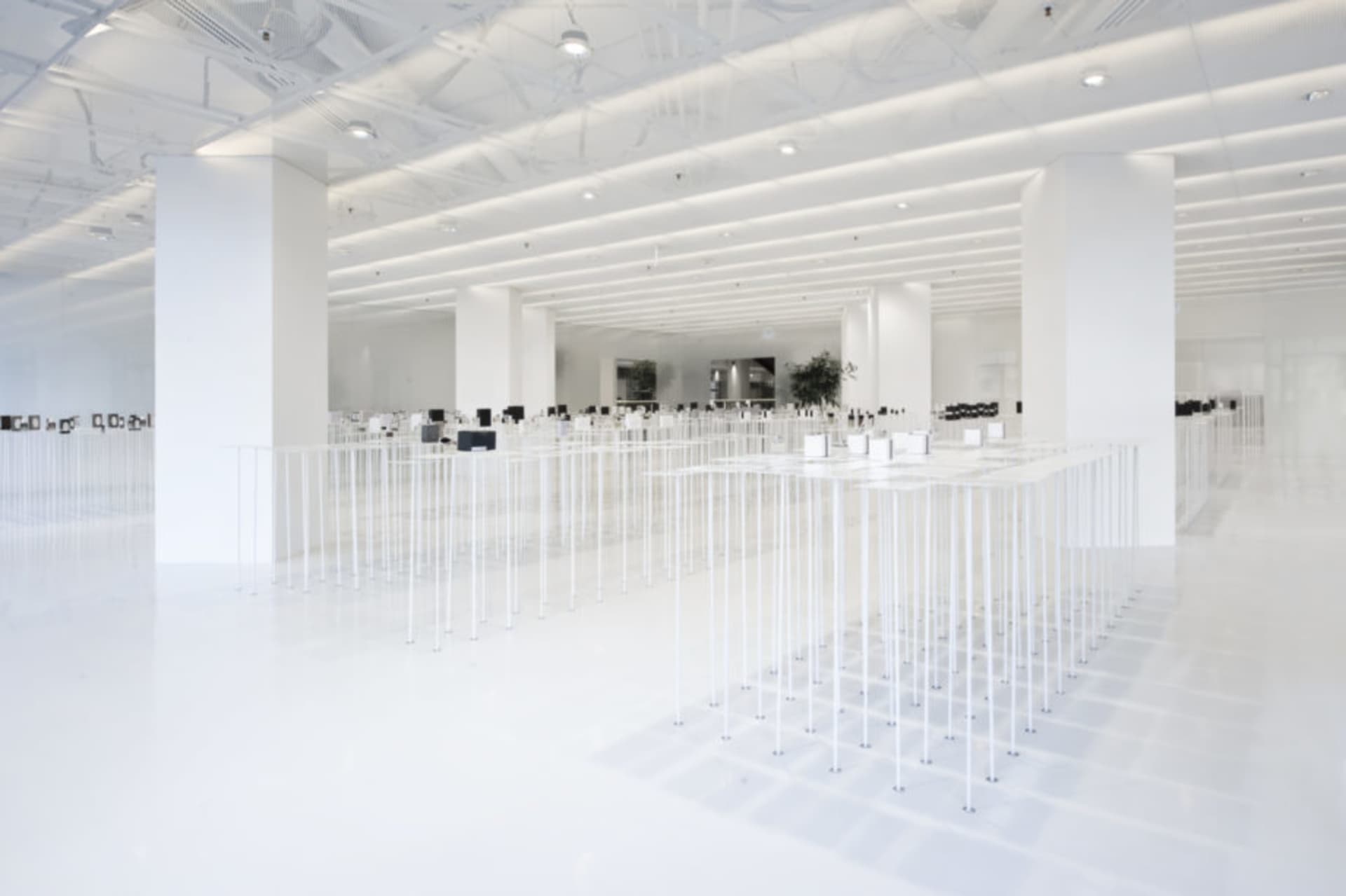 An empty minimalist office space with white flooring and walls.