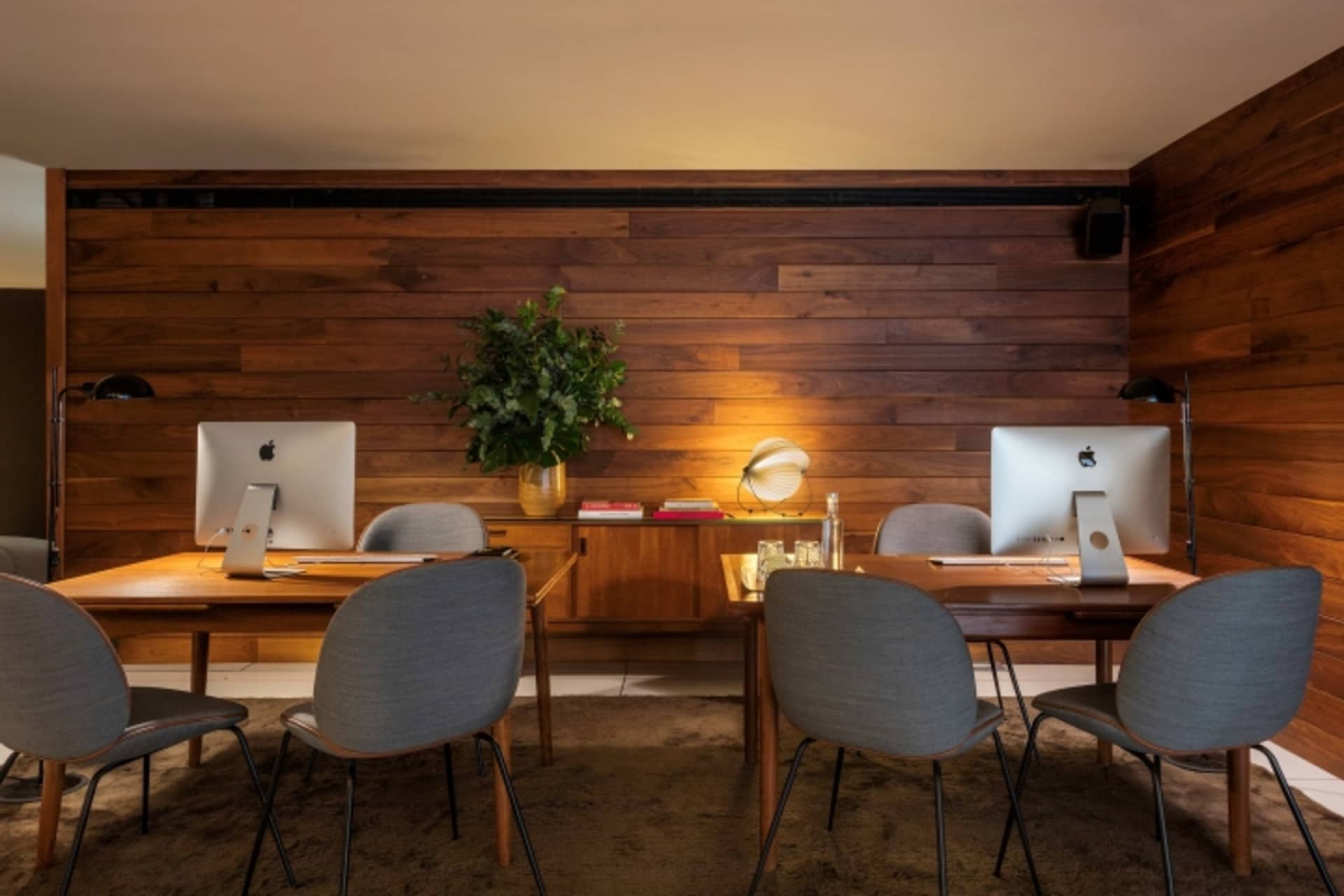 Modern, industrial-style office coworking space with wooden walls and furniture.