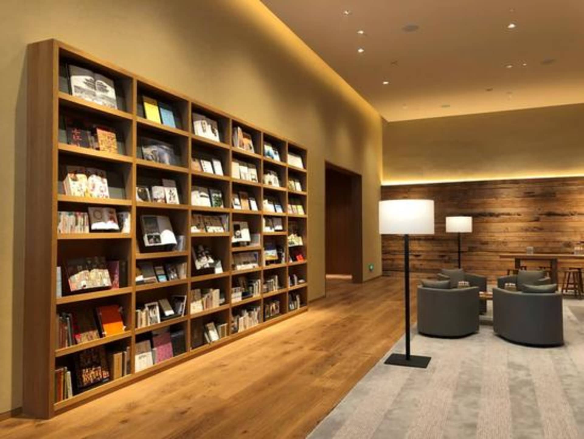 A spacious, modern library with wooden shelves filled with various books andKnock Knock Wood Cutting Board - Cherry Blossom (
