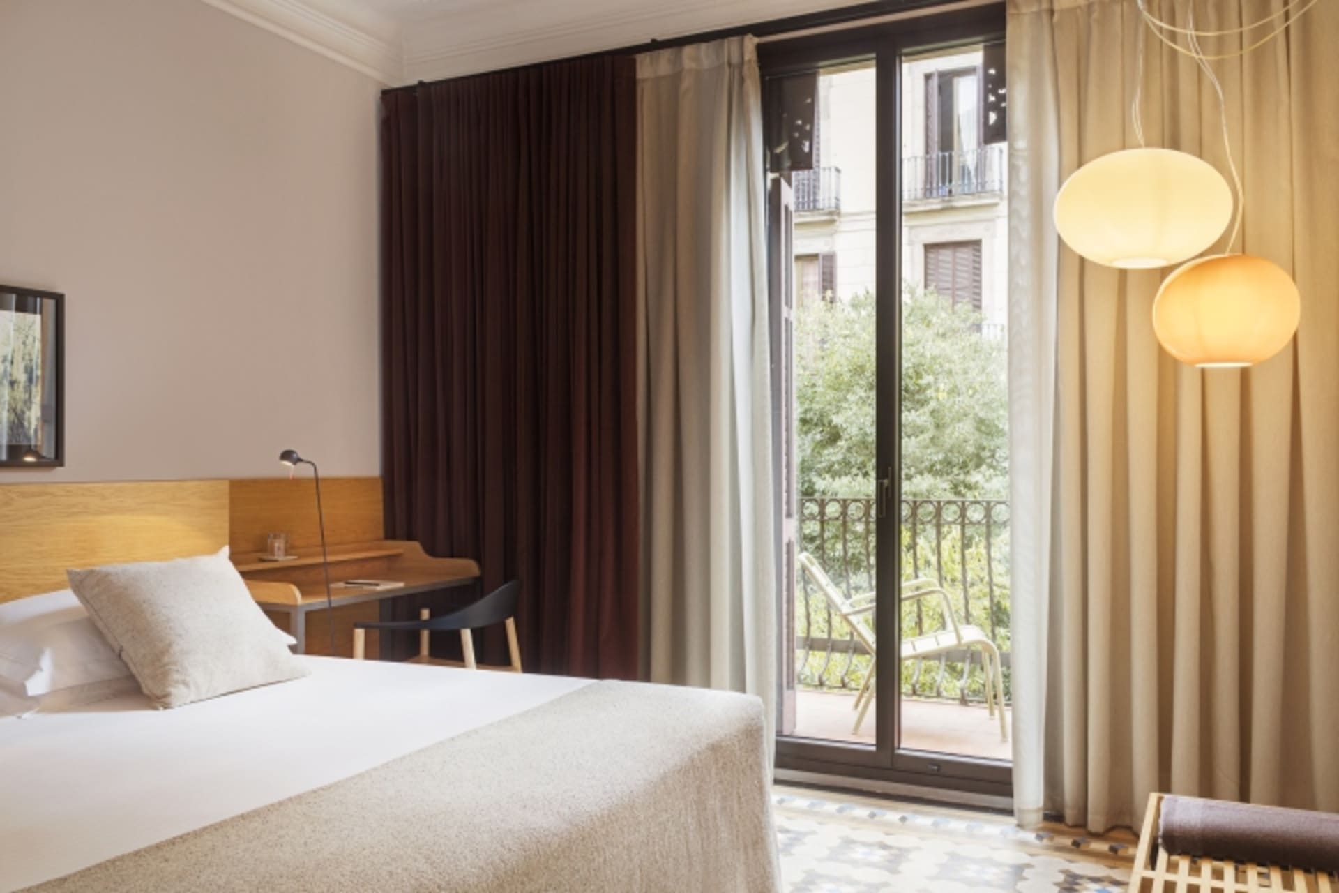 A modern bedroom with a clean, minimalist design featuring neutral-toned fabrics and furniture.