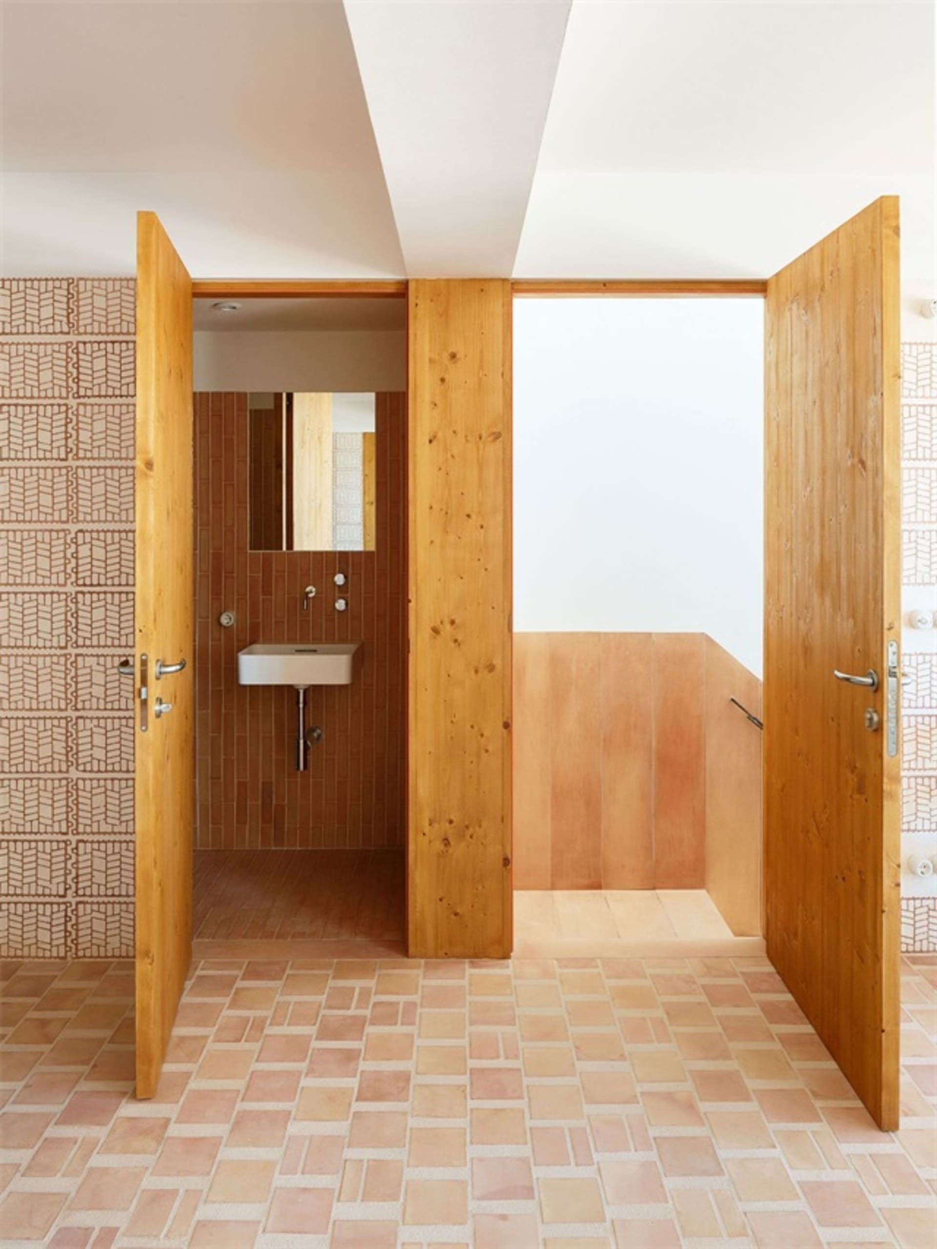 Modern bathroom featuring ceramic tile flooring and walls with a minimalist design.