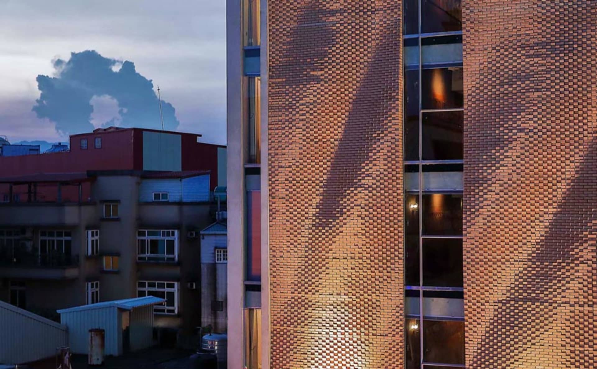 磚造建築在夕陽映照下，立面散發溫暖光輝。