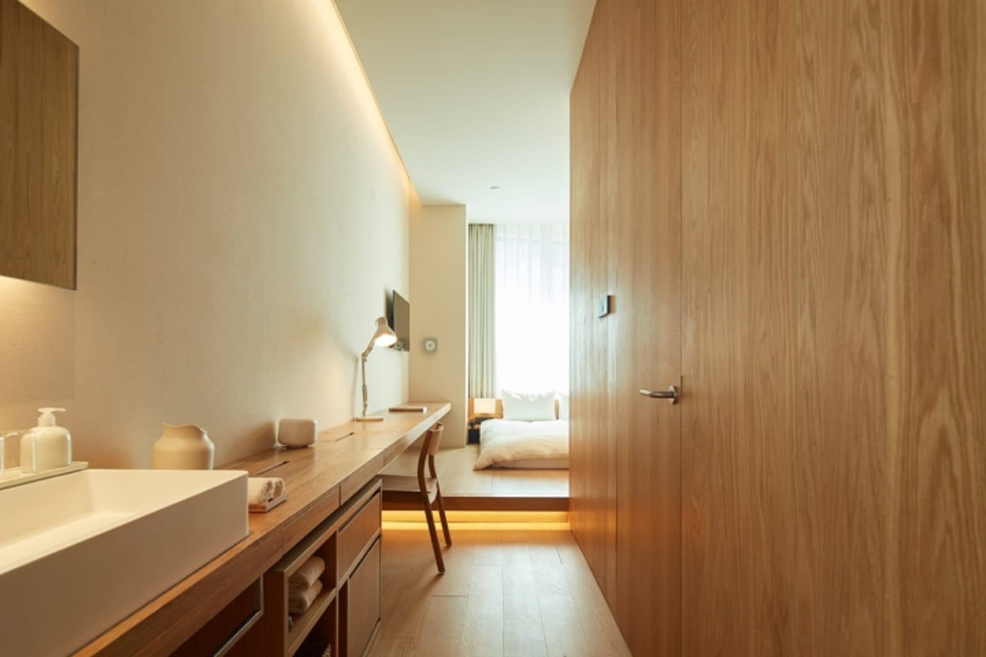 A minimalist bedroom featuring wood finishes and a simple, functional design.