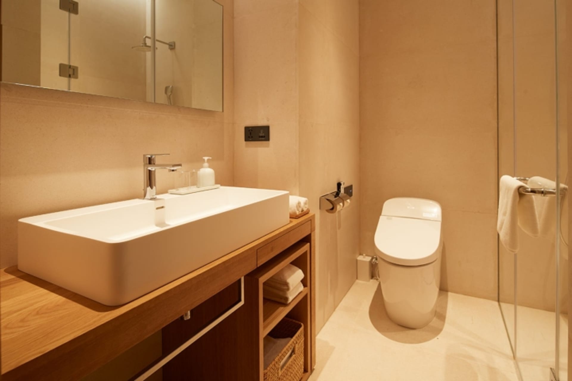 Modern bathroom with a sleek ceramic sink and toilet, featuring minimalist design elements.
